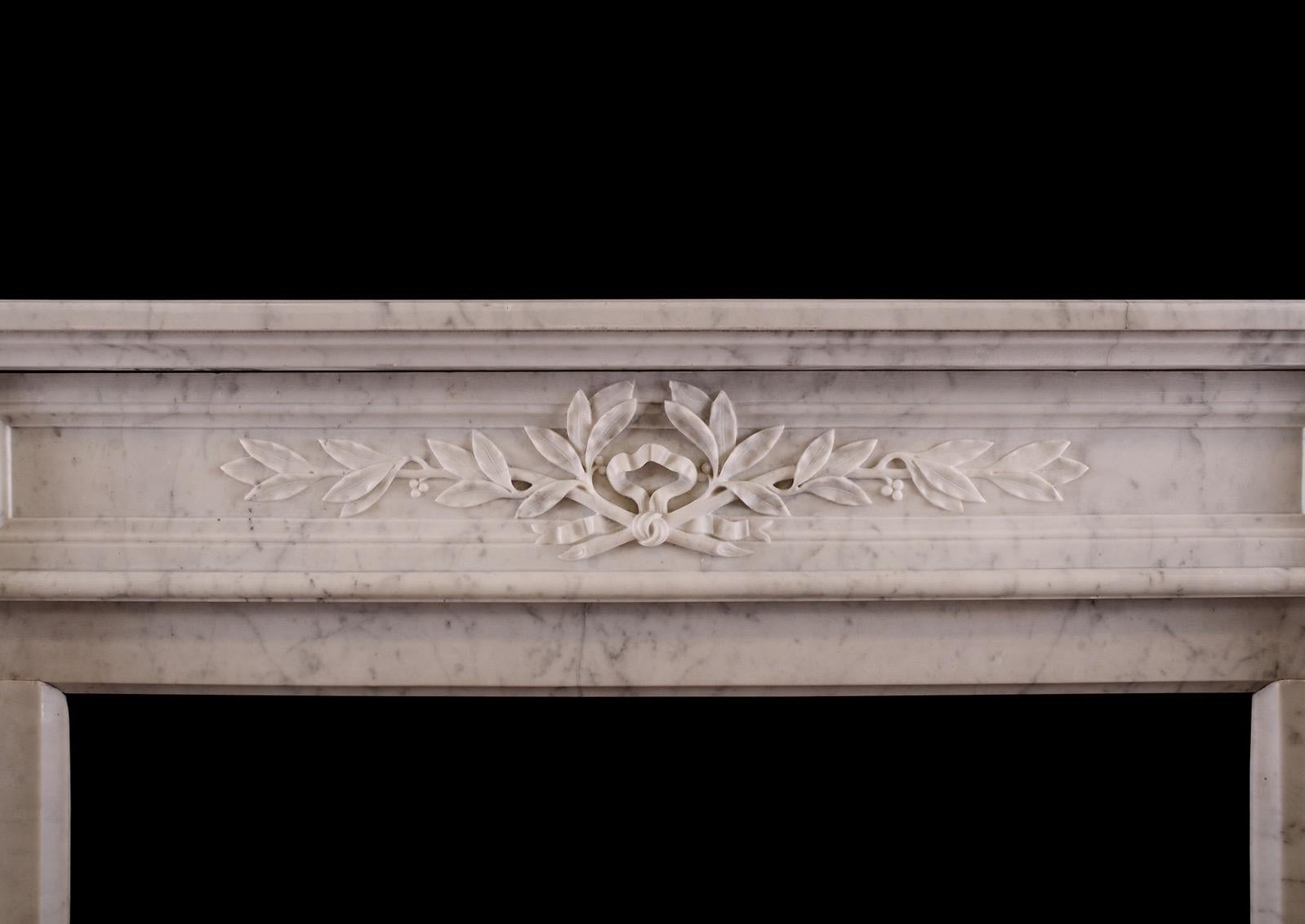 A French Carrara marble fireplace in the Louis XVI style. The stop-fluted jambs surmounted by carved square paterae. The panelled frieze with leaves and berries. Moulded shelf above. French, 19th century. Small scale, well suited for a smaller