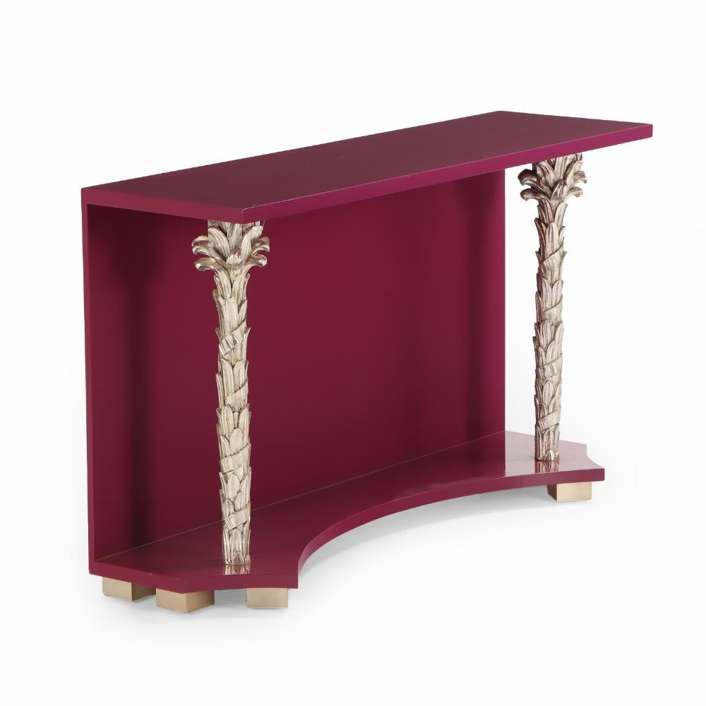 The magenta / plum lacquered rectangular top resting on two beautiful silver palm frond supports joined by a lower shelf with concave front flanked by cut corners. This is the eye-catching glam you've been needing to add to your entryway!

Serge