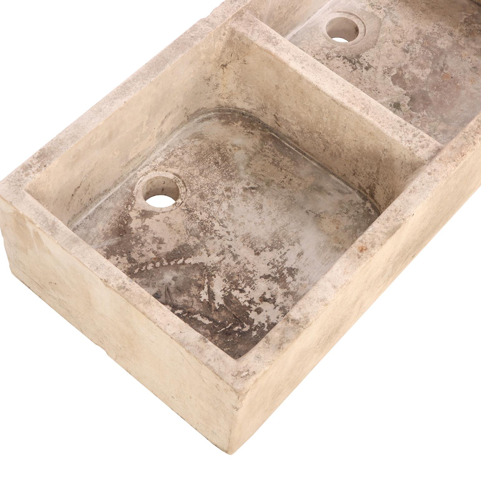 Ausgeführt in einem warmen, verwitterten Stein, der die natürliche Patina und die Werkzeugspuren von Alter und Gebrauch aufweist. Ein funktionelles und zugleich skulpturales Stück, ideal für Gartenzimmer, Küche oder Bad, das die rustikale Eleganz