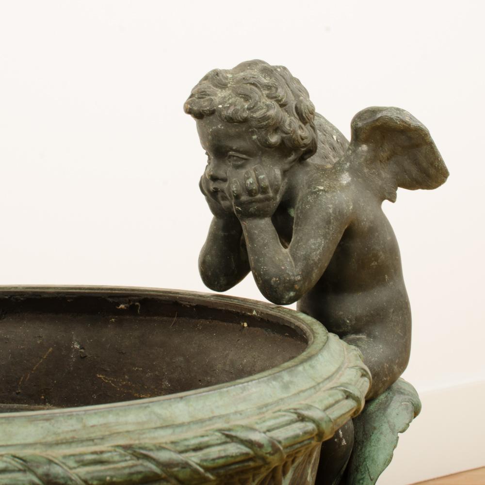 A French cast bronze garden urn with cherubs, circa 1910. This is a copy of an Urn at Versailles.