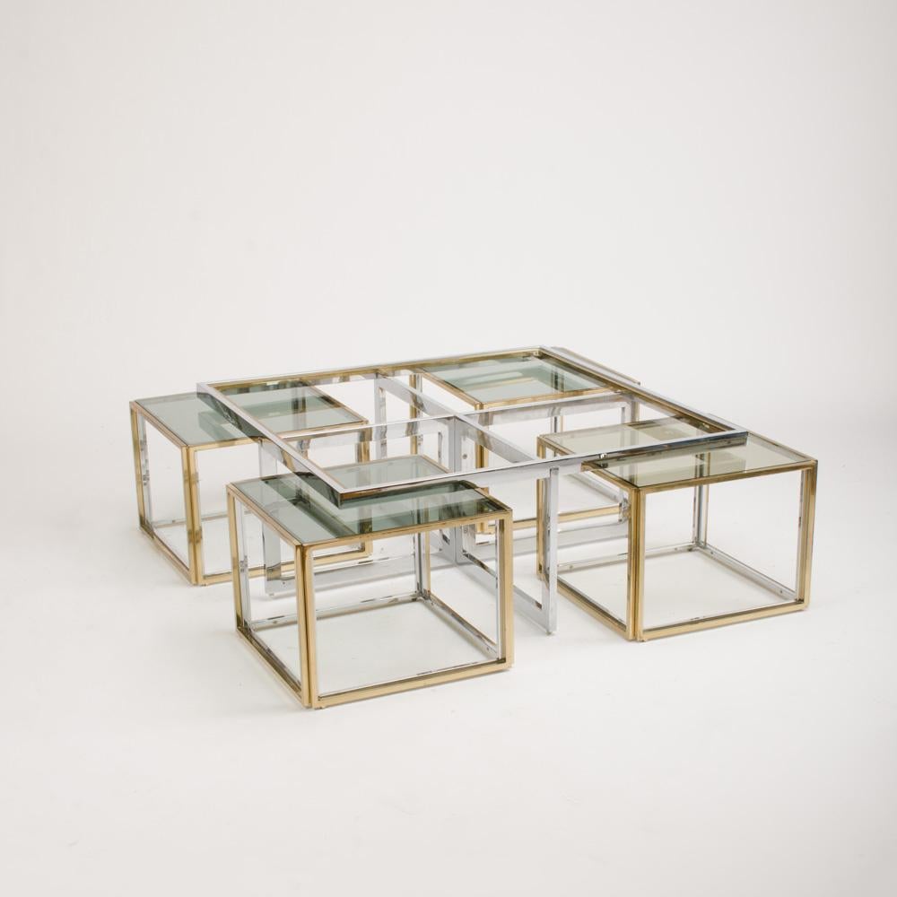 An elegant chrome and glass coffee table with four end tables that nest under the coffee table in brass and chrome, designed by Jean Charles, made by Maison Charles circa 1978.
 