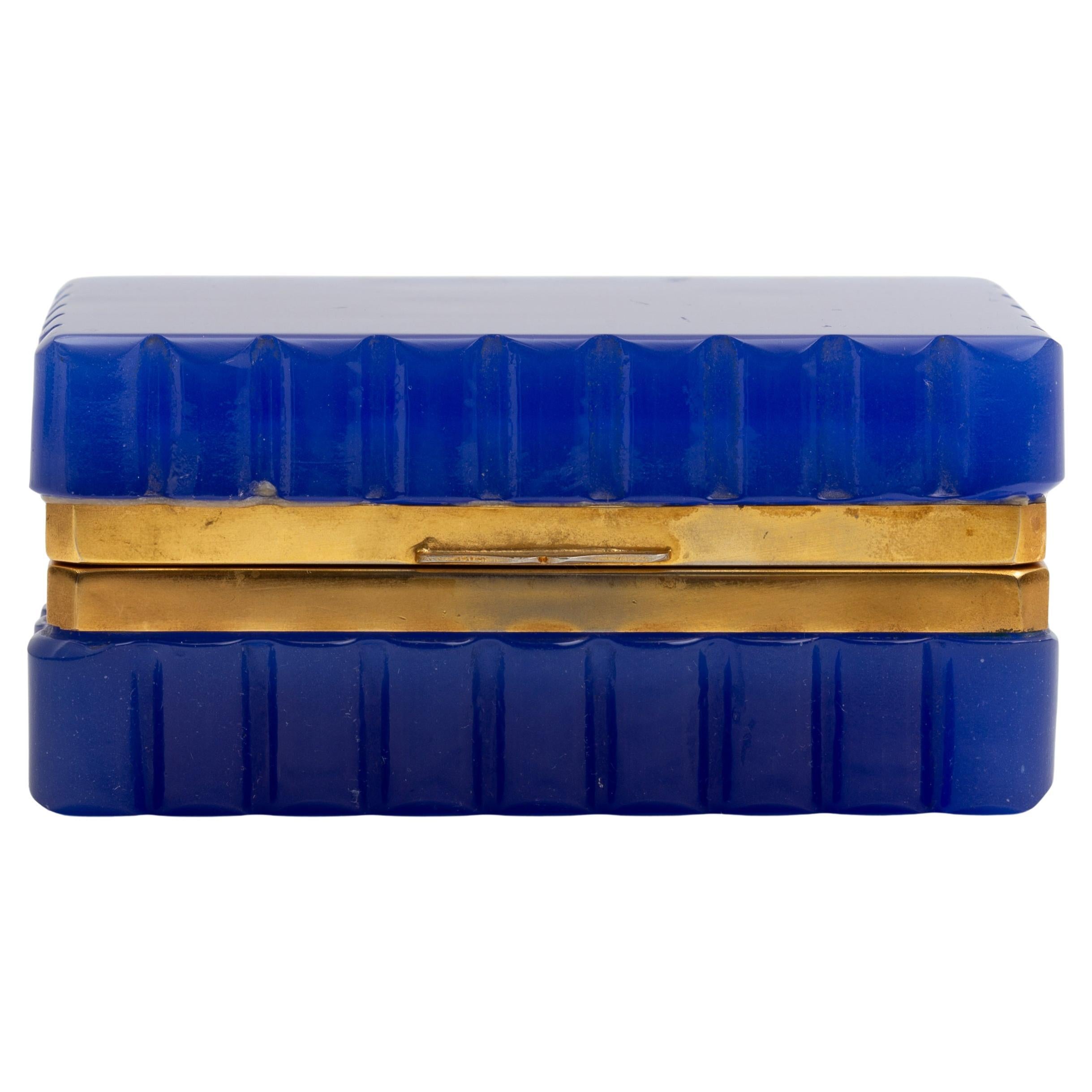 Boîte française en cristal opalin bleu cobalt avec montures en bronze doré et bords festonnés

La boîte est formée dans une forme rectangulaire avec une surface extérieure festonnée qui crée un rythme uniforme autour des quatre côtés. Son corps