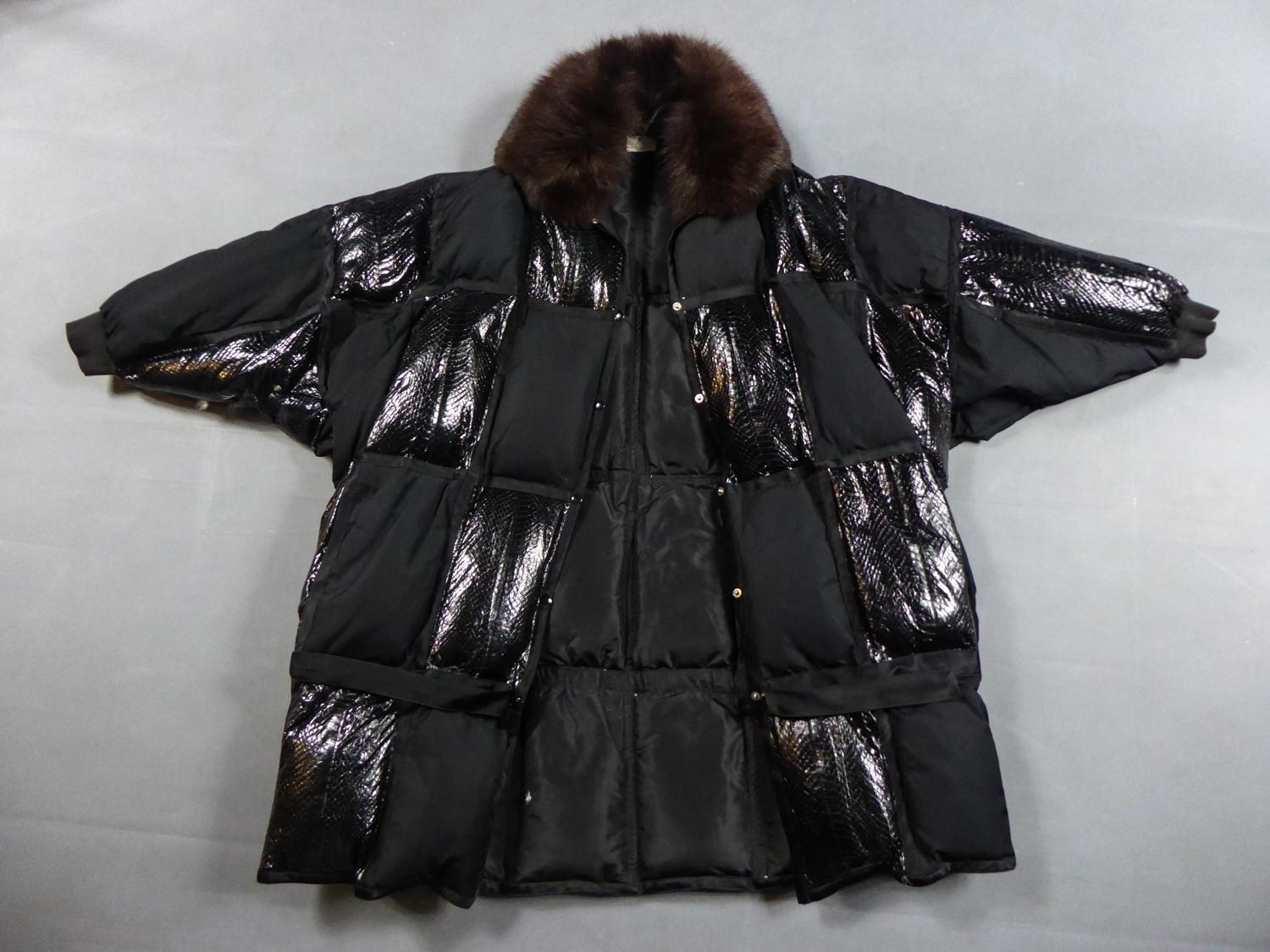 Circa 1990/2000
France

Parka or long down jacket in goose down from the Haute Couture Designer House Courrèges and dating from the late 1990s. Checked quilted effect in synthetic snakeskin. Loose cut called Oversize, collar in brown mink and long