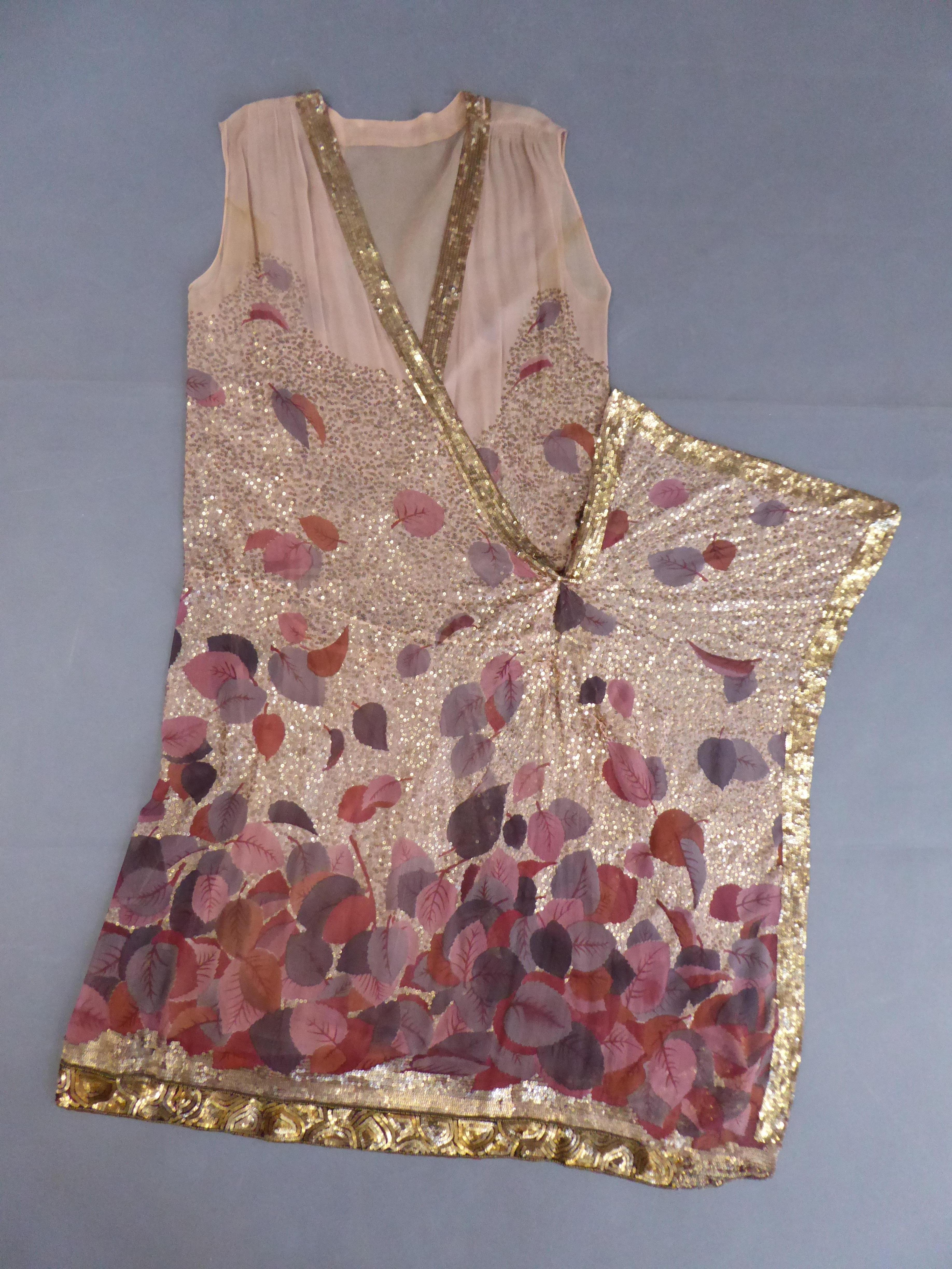 Circa 1928
Paris France

A printed chiffon silk and gold sequined mid-long sleeveless tunic dress attributed to Jeanne Lanvin. Printed background in gradient of falling autumn leaves whose voids are entirely embroidered with random seeding golden