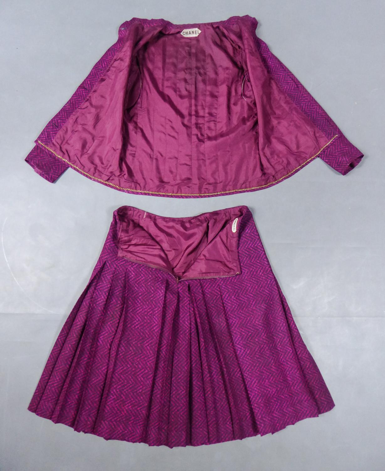 Circa 1980
Francia
Raro completo Chanel Haute Couture con gonna e giacca per l'estate, risalente ai primi anni '80. Serge di seta stampato con motivo fushchia a zig zag su sfondo bordeaux. Giacca con collo alla coreana e catena in ottone cucita