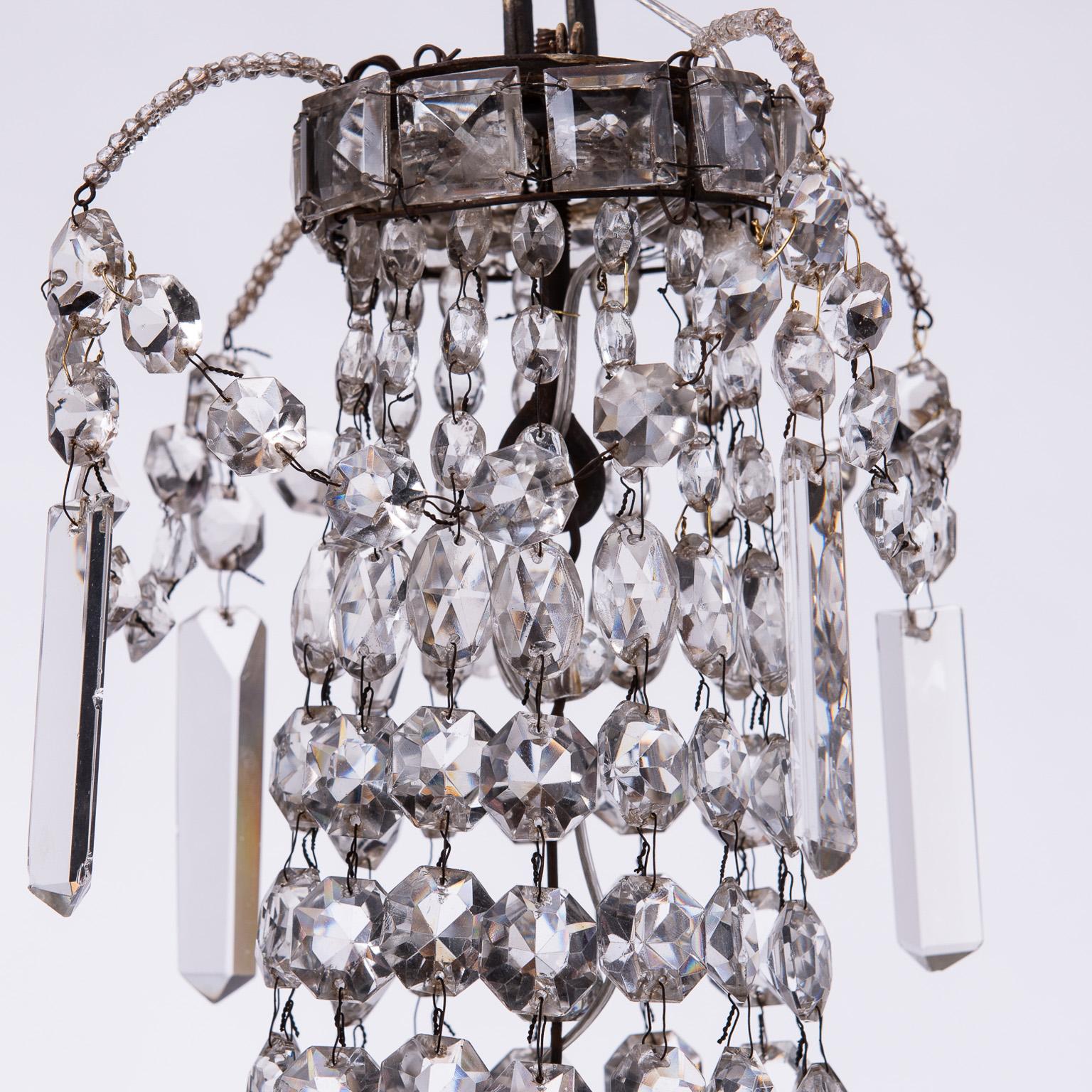This Classic French chandelier is made particularly glamorous by a ring of super long crystals at the center, which refract the light beautifully. It has three interior lights and was recently wired for American circuits.

Measures: 35” high
19”