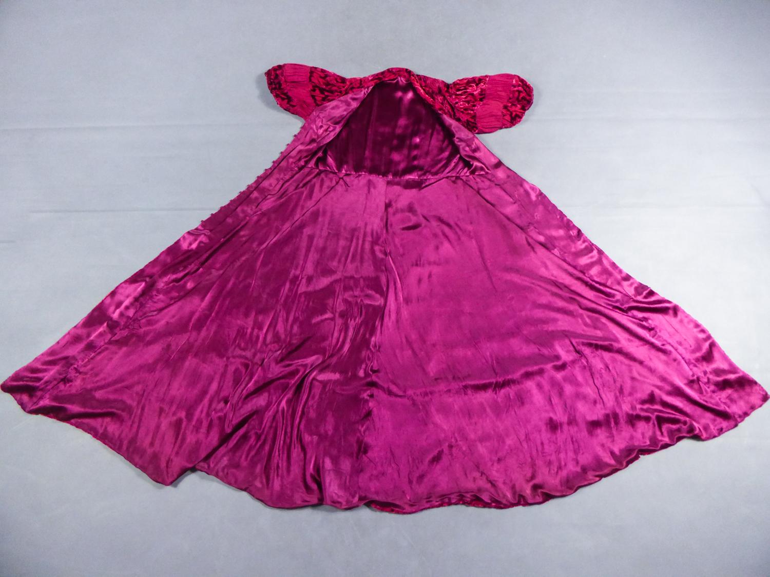 Circa 1940/1950

France

Beautiful evening coat dress in devoré velvet and silk crepe Fuschia dating from the Second World War. No labelled. Strips of devoré silk velvet with Art Deco flower motifs, alternating with a matching silk crepe highlighted