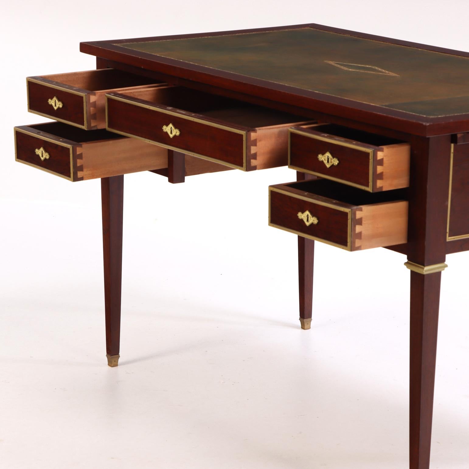 Crafted in mahogany with a leather writing surface, this elegant desk features five drawers, bronze mounts, leather pull-out slides, and square tapering legs. Combining refined Directoire-inspired design with mid-20th-century craftsmanship, it
