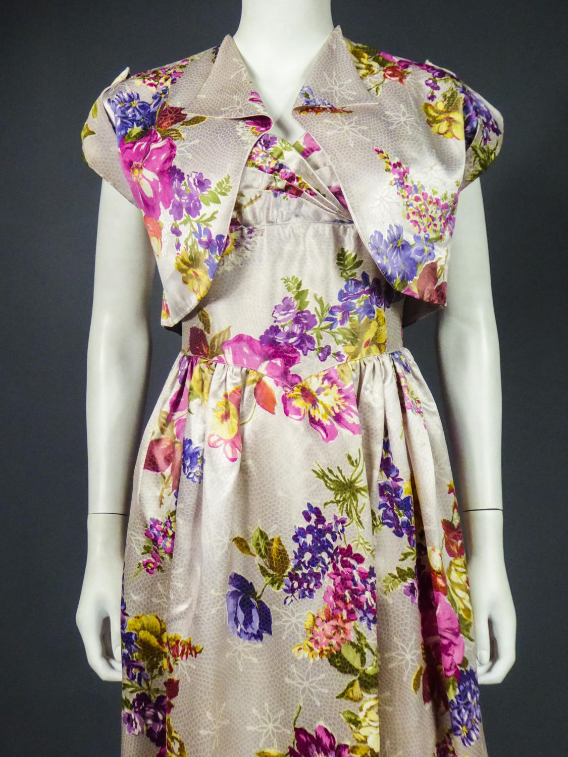Circa 1965-1970
France

Dress and bolero in waxed printed silk satin from the 1960s with no label. Long dress with finely pleated skirt at the waist ending in a point on the front. Fitted bustier with small straps and concentric pleated work