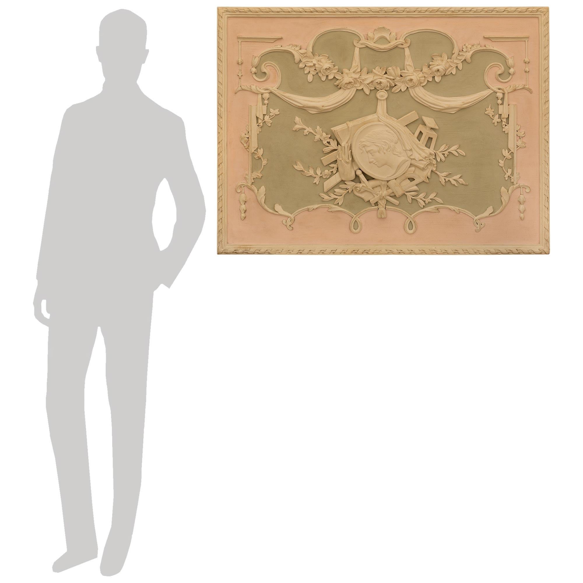 A beautiful and most elegant French early 19th century Louis XVI st. patinated Wood wall panel. This truly stunning rectangular wall decor/plaque is centered by a central medallion of an artist surrounded by his artistic tools accented with laurel