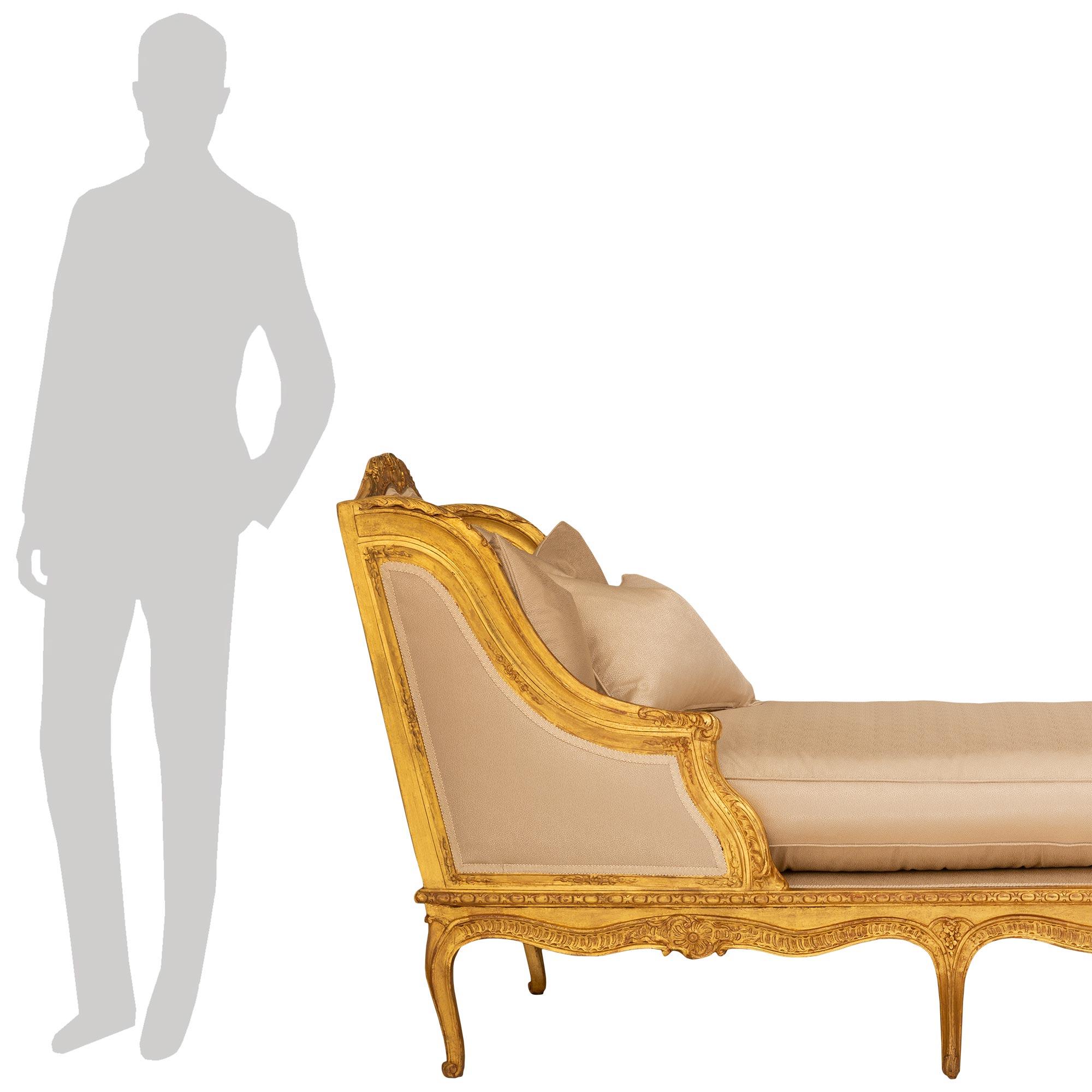 



An exceptional and most unique French early 19th century Regence st. giltwood Récamier chaise. The chaise is raised by six elegant cabriole legs with top carvings of flowers and the scalloped shaped apron displays a central Rocaille reserve
