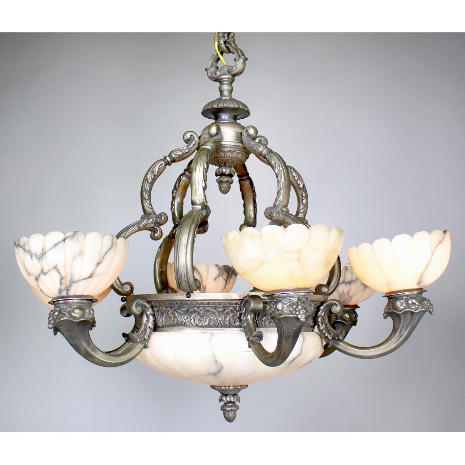 A French early 20th century Art Deco and silvered bronze carved veined white alabaster six-light chandelier. The carved circular plafonnier with a silvered apron, all above a banded frame surmounted with six alabaster lights above silver plated