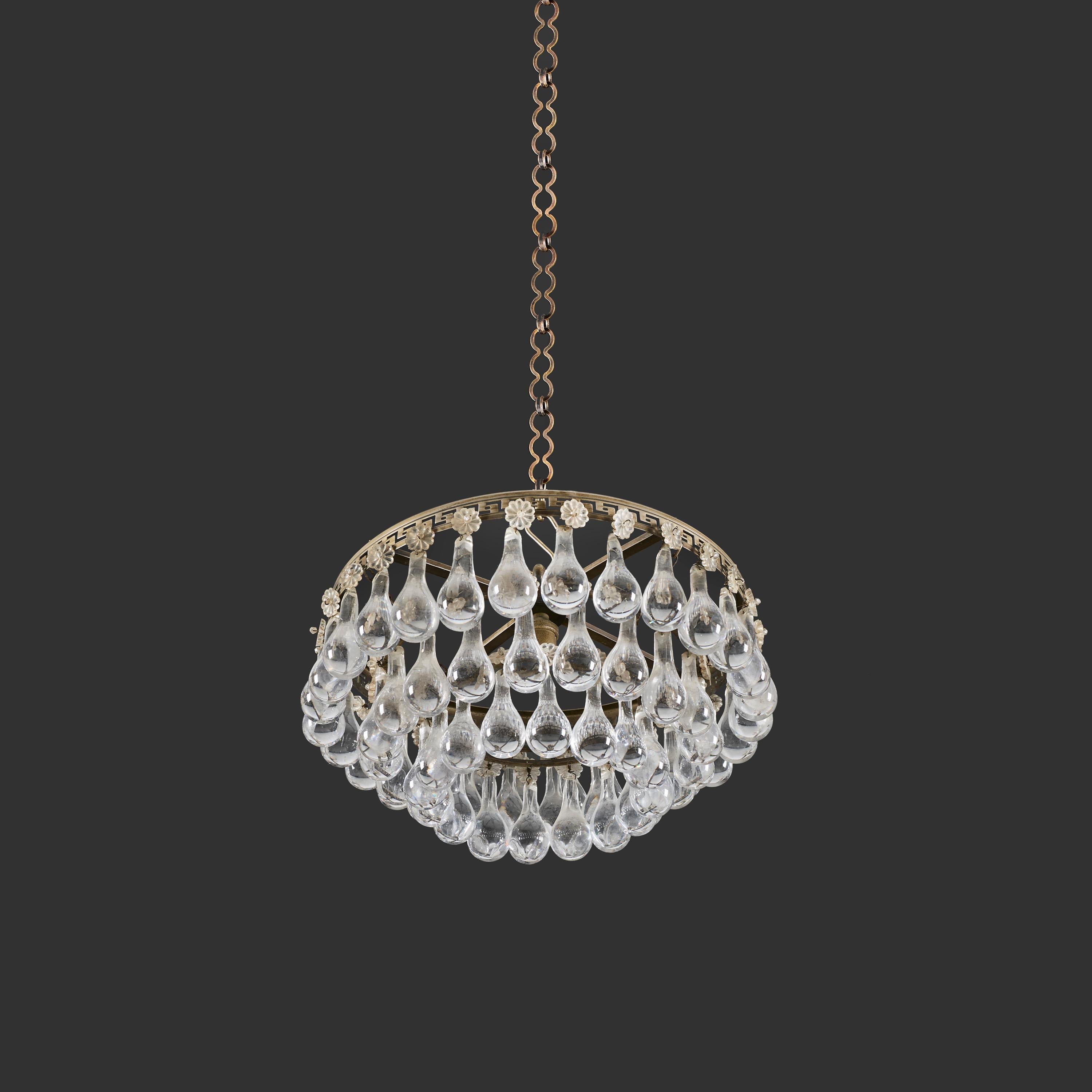 Francia, circa 1920

Una lampada a sospensione circolare in stile Art Decor francese, ornata da gocce di vetro a più livelli e patere che pendono da una cornice in bronzo, decorata con una fascia di motivi a chiave greca. 

Altezza 19,00 cm
Diametro