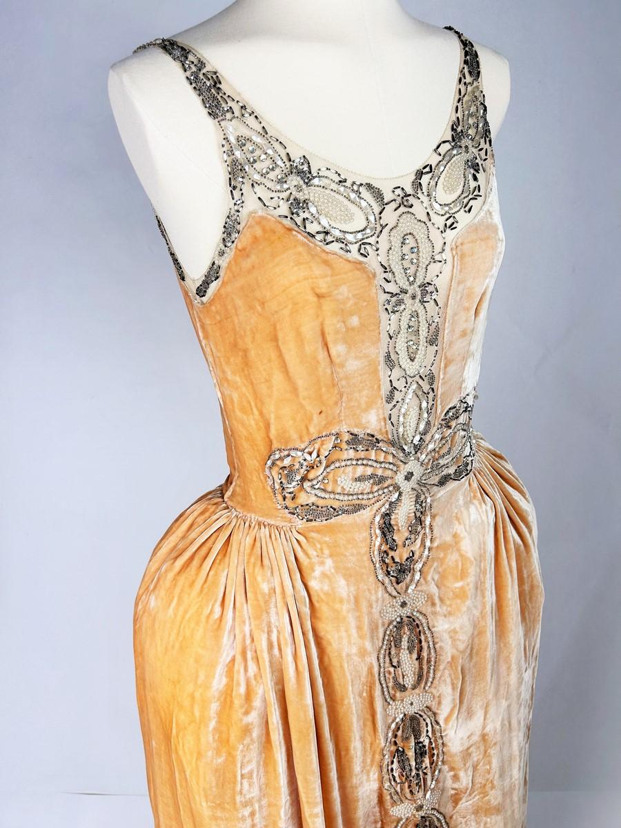 Autumn Winter 1924-1925
France

Jeanne Lanvin Haute Couture Robe de Style numbered 88072 (?) from the Autumn Winter 1924-1925 collection. Long dress with large décolleté on a curved bustier, sleeveless and thin straps in peach velvet . A skilful
