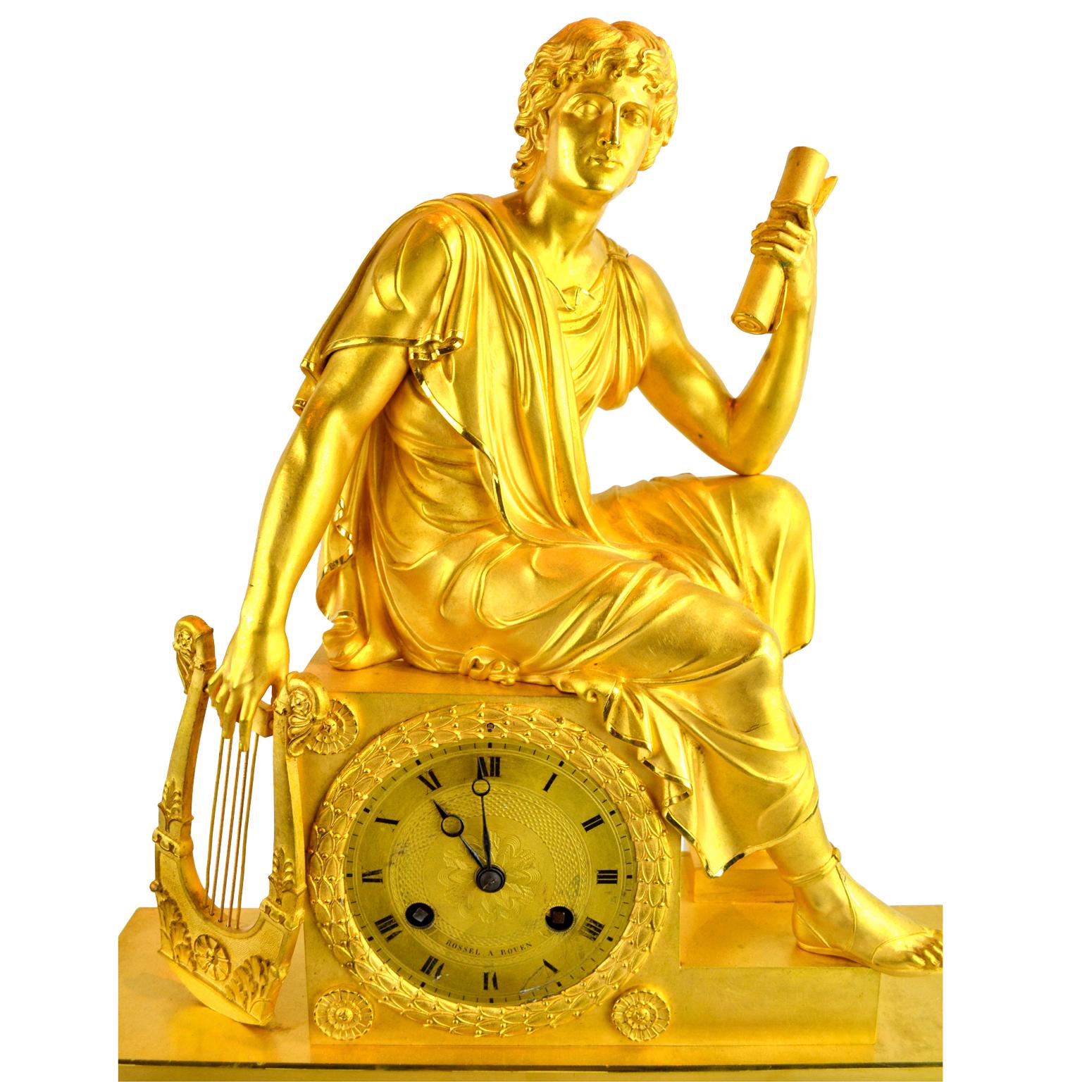 Pendule figurative de l'Empire français représentant un jeune Romain tenant un parchemin en bronze doré montrant un jeune assis, drapé de façon classique, tenant une lyre dans une main et un parchemin dans l'autre. La partie inférieure rectangulaire