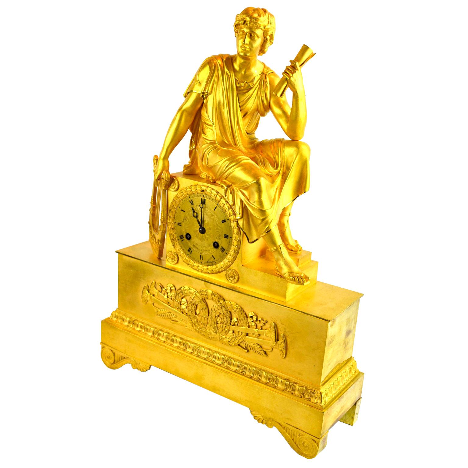 Horloge figurative en bronze doré de l'Empire français représentant une jeune fille romaine tenant un rouleau en vente