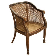 A French Empire Mahogany Frame Cane Bergere Armchair With Rams Head Terminus