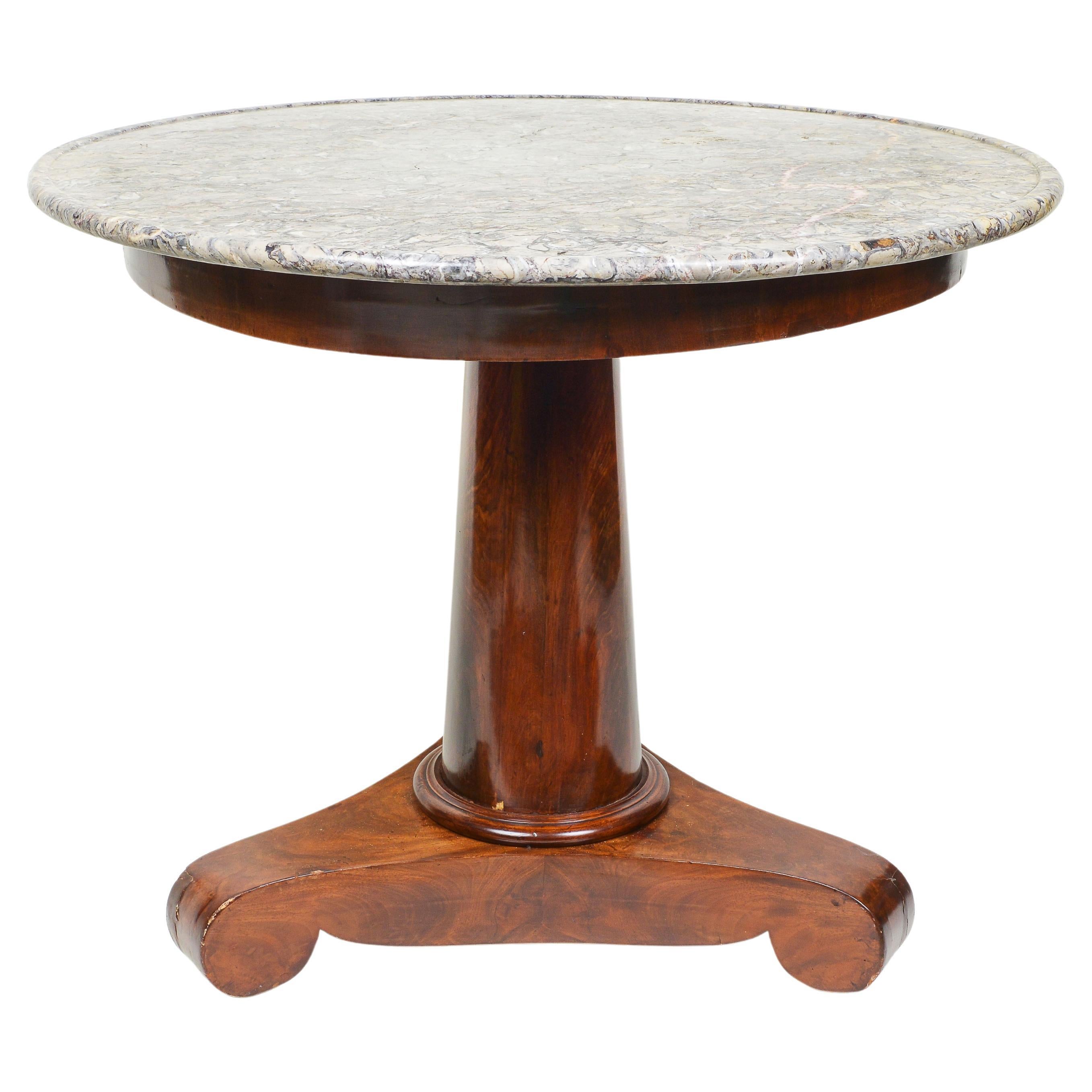 The light gray fossilized marble top supported on center column on a tripod base.