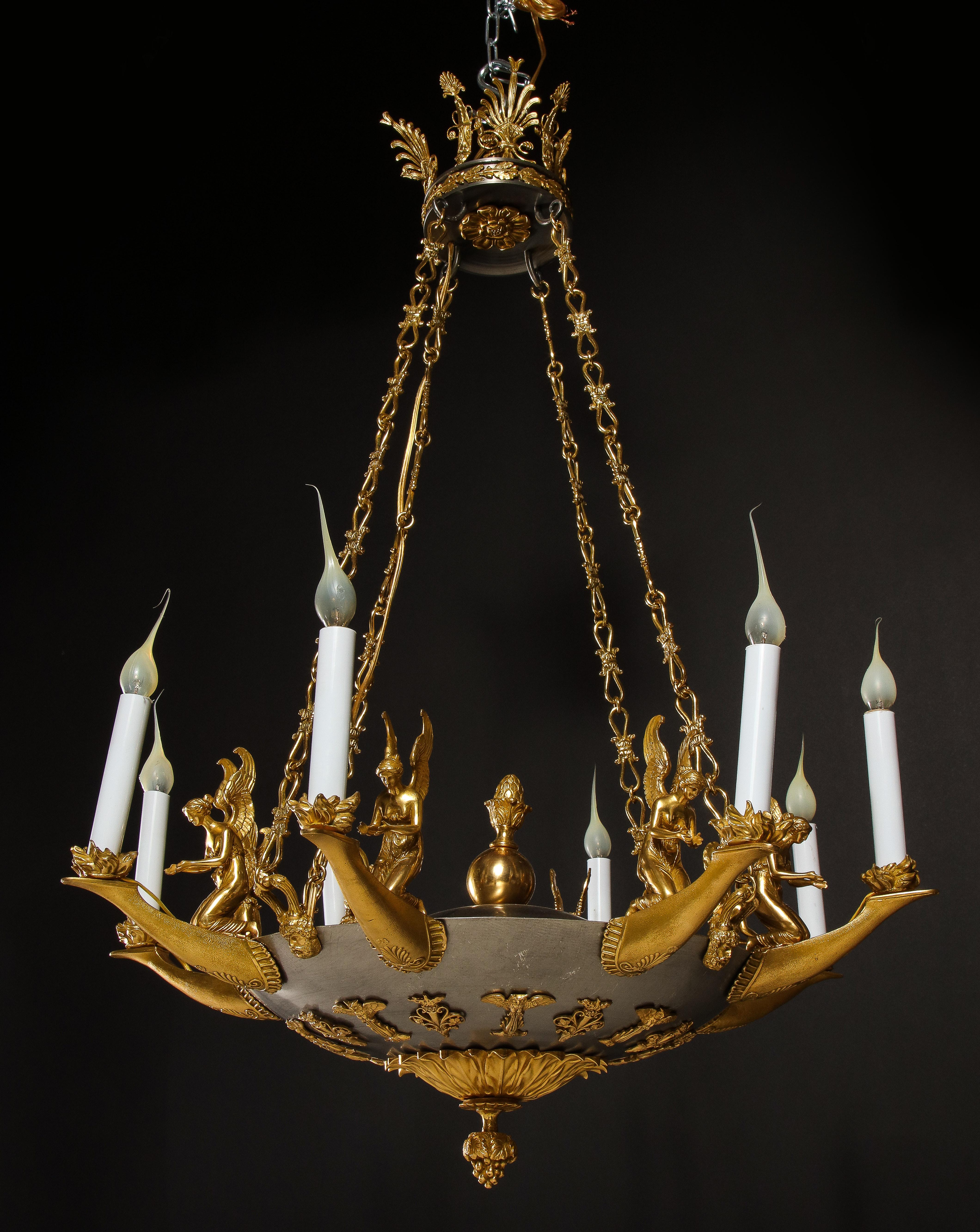 A fine and unique Antique French Empire style gilt bronze and steel multi light figural chandelier of great detail embellished with gilt bronze Neoclassical kneeling figures of women depicting flames which represent light. This fine chandelier is
