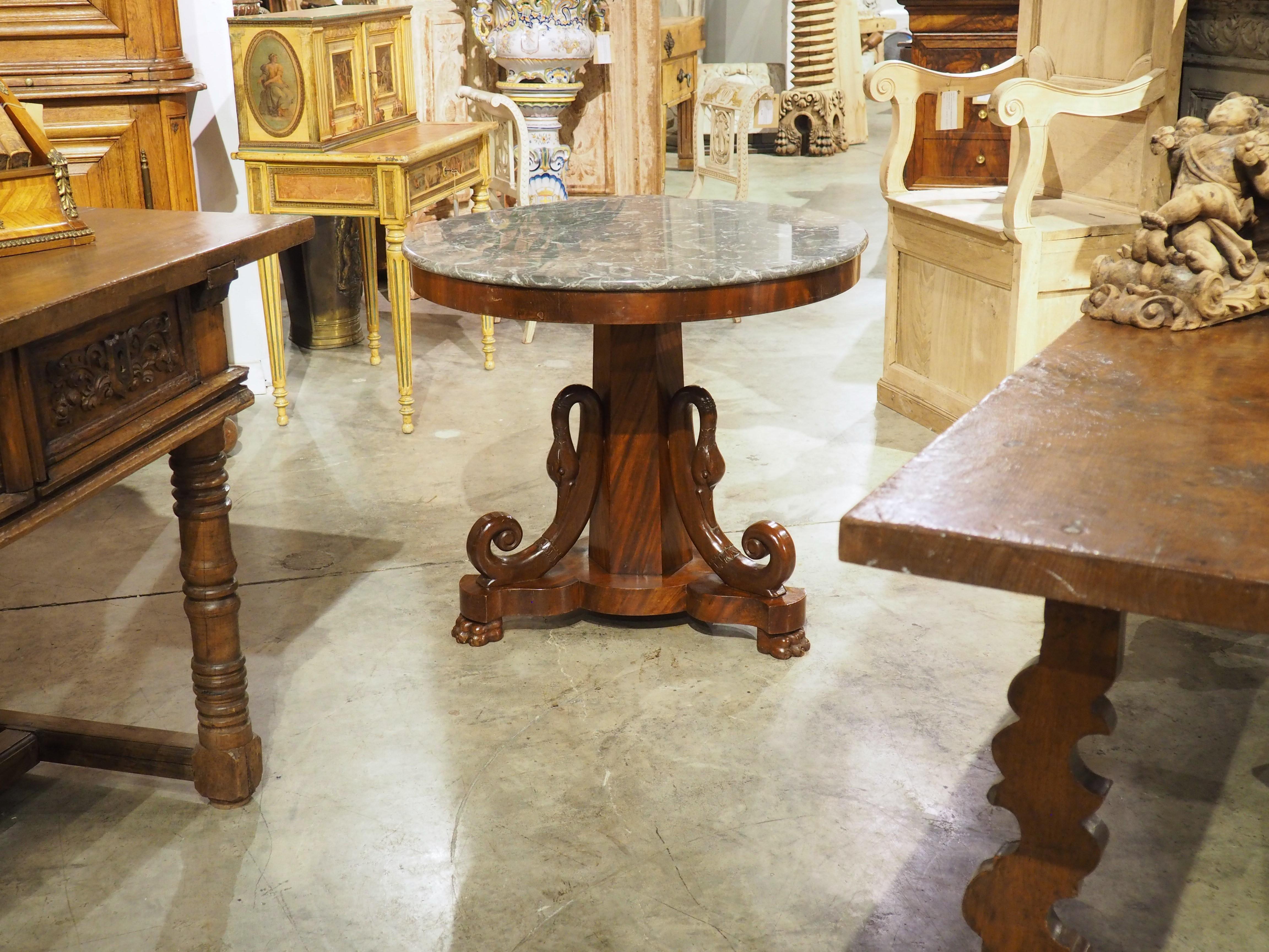 More information coming soon…

Hand-carved in the Empire style, this French mahogany center table dates to the 1800s.  A thin marble tops a circular platter that is supported by a hexagonal column.  Every other side of the column has a supple swan