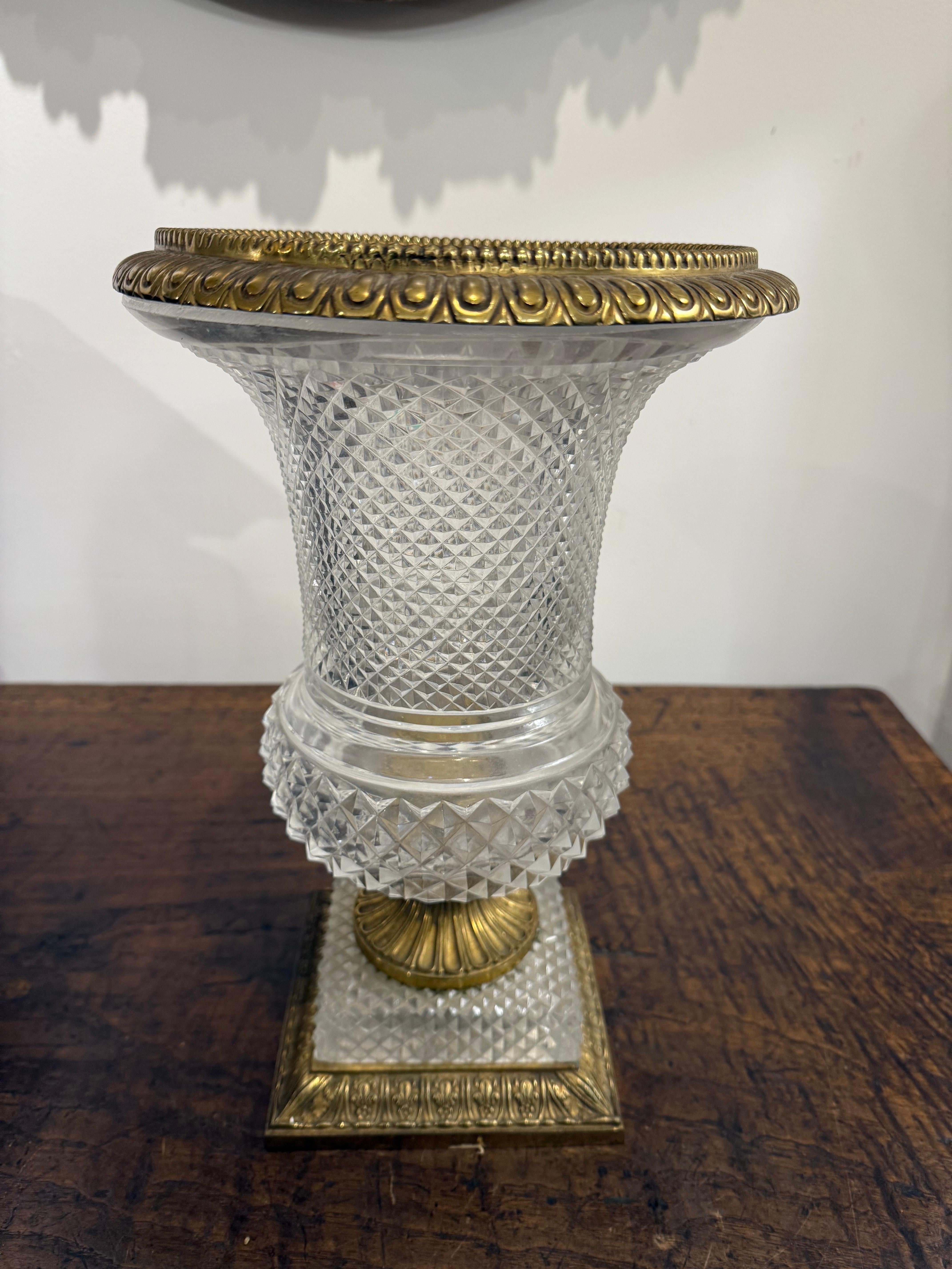 Urna de cristal tallado y bronce d'Oré de estilo Imperio francés, S. XIX

Procedencia: Colección privada australiana. 

Descripción:
La urna de vidrio tallado se ensancha hacia un labio evertido de ormolina con moldura de lengüeta y el borde