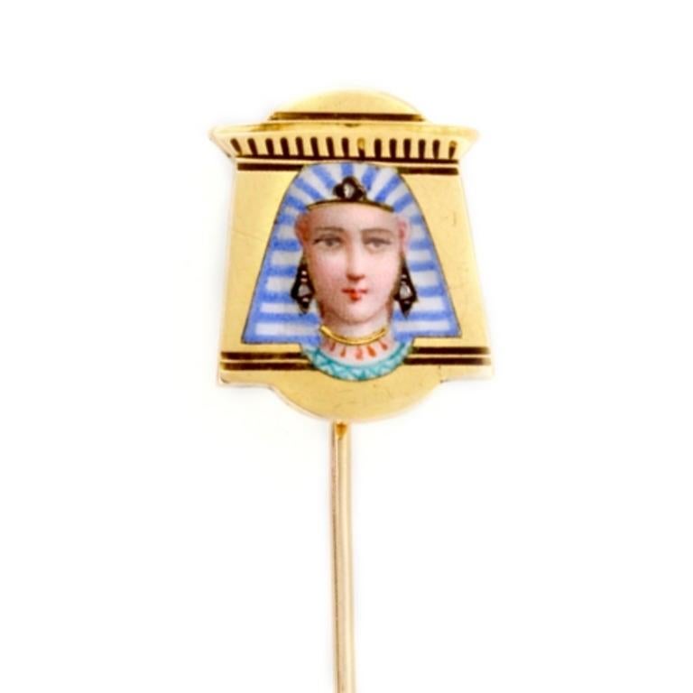 A late nineteenth century enamel and diamond egyptianesque stick pin, the Egyptian queen with enamel and rose-cut diamond set headdress, to a shaped yellow gold mount with architectural motifs, French import marks to the pin, circa 1880, the
