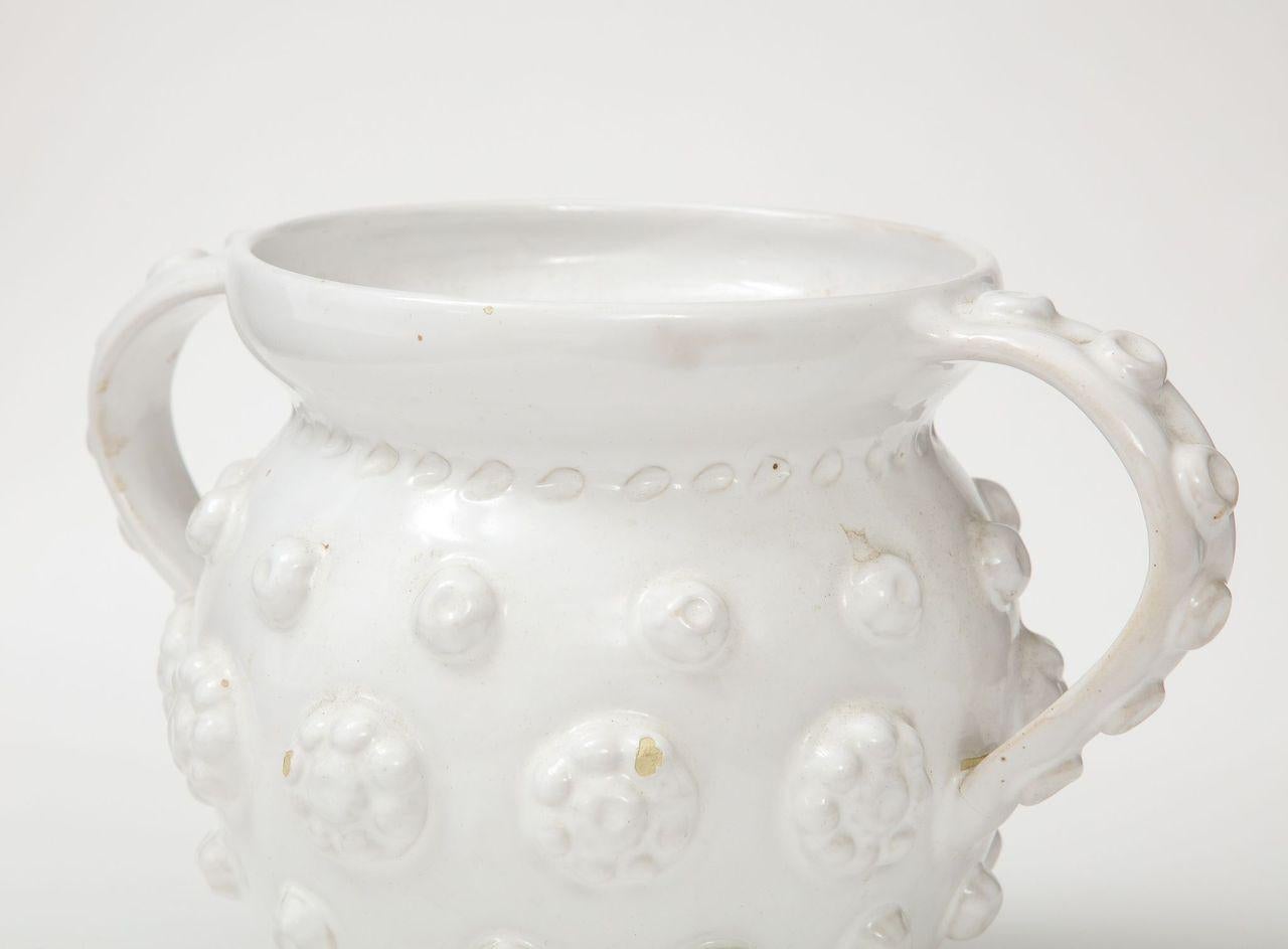 A unique and beautiful faience jug attributed  to French ceramicist Emile Tessier. One of a series in our inventory, this vase not only has a beautiful form, but it features hand-sculpted details on its exterior.  It is beautiful on its own, but