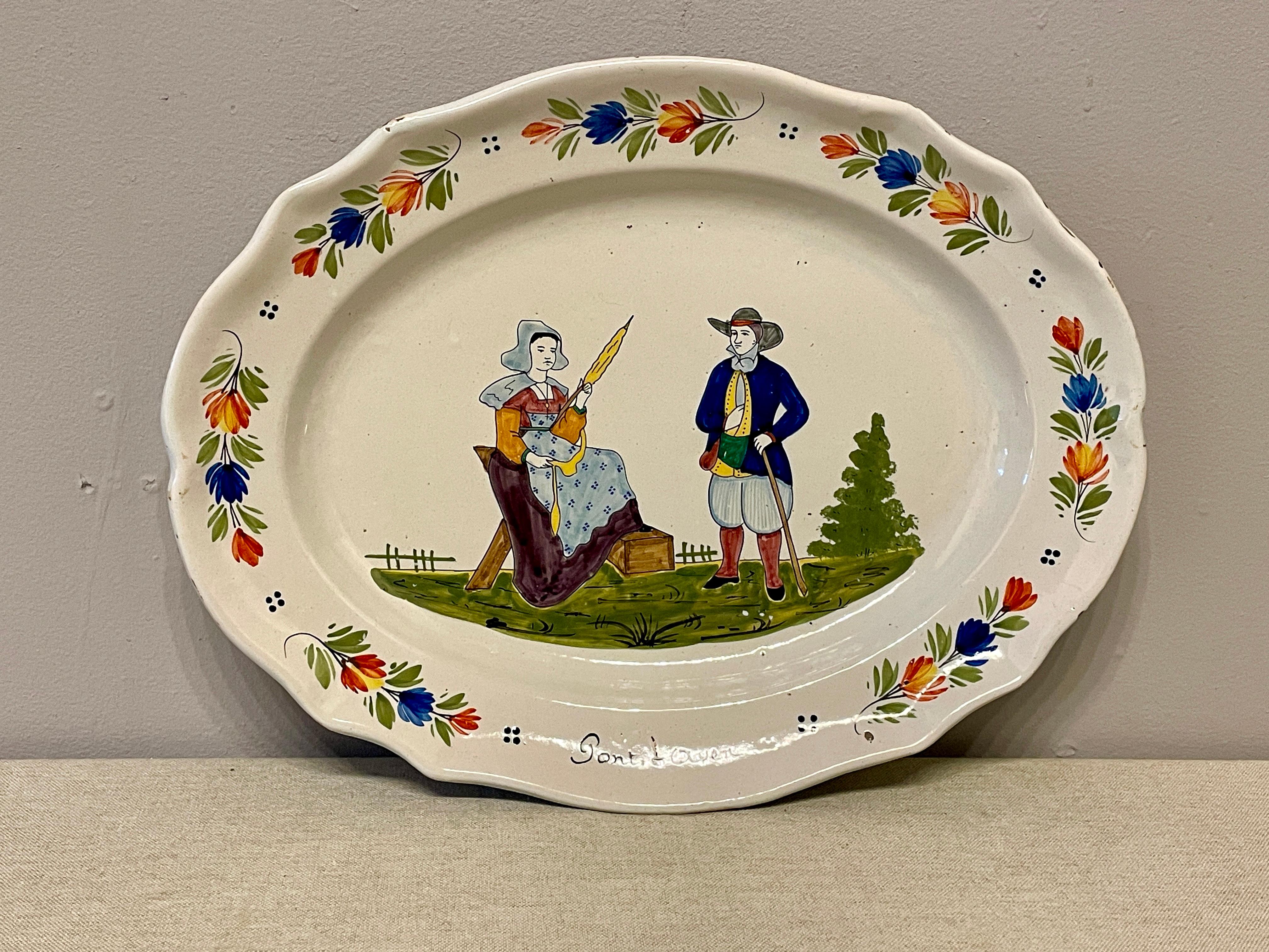 An early 20th century French Faience Quimper platter from Brittany, signed HB, depicting a couple in the field with a women knitting and man watching. The platter is in good condition and no hairline were noted. Minor wear on the edge and no chips.