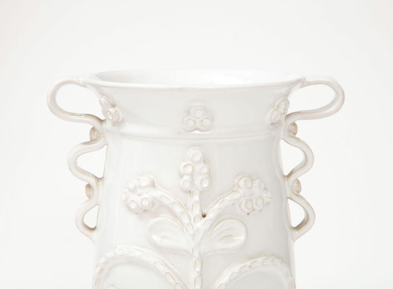 A unique and beautiful faience jug attributed  to French ceramicist Emile Tessier. One of a series in our inventory, this vase not only has a beautiful form, but it features hand-sculpted details on its exterior.  It is beautiful on its own, but