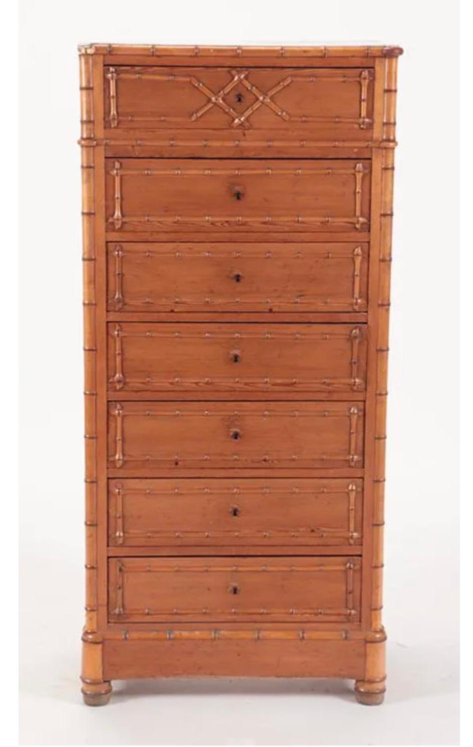A rare French faux bamboo and burl wood Lingerie Chest from the second quarter of the 19th century, with conforming marble tops and geometric design. This tall and narrow chest features a white veined marble top sitting above seven drawers. Designed