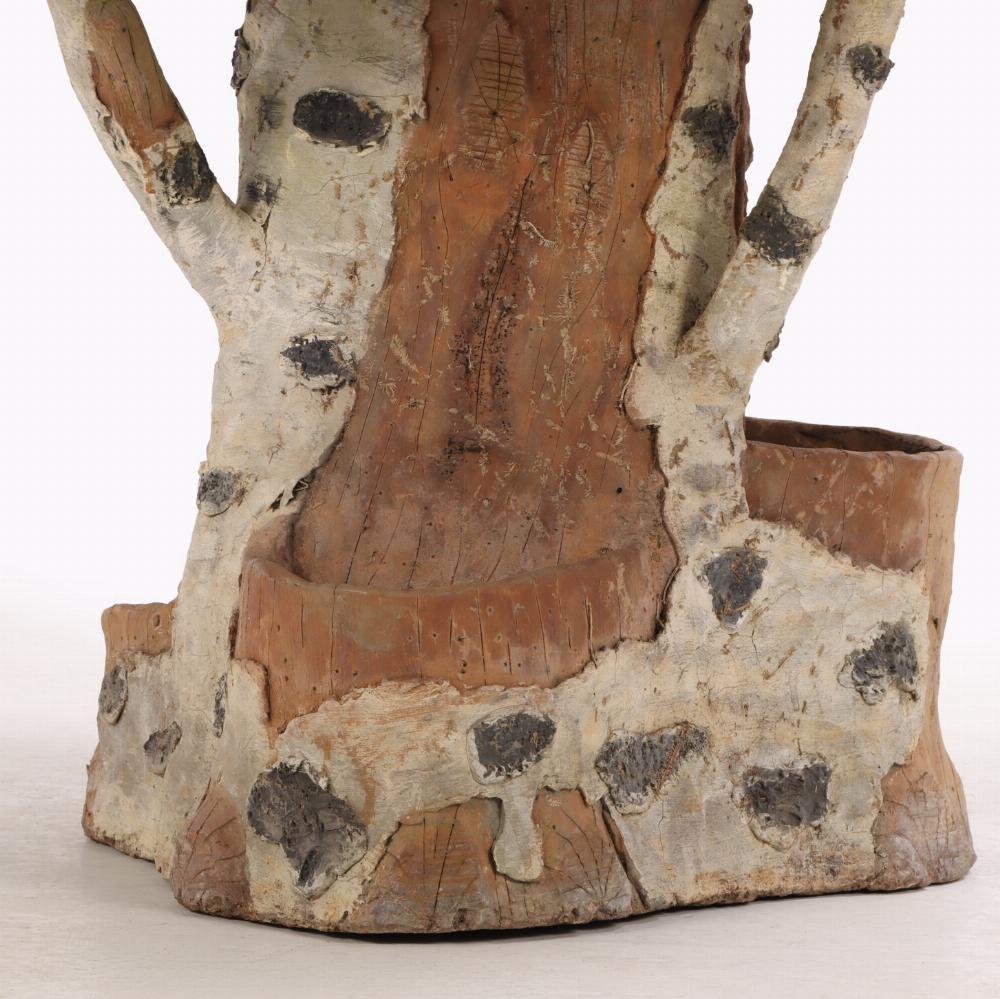Constructed of two pieces, this whimsical table has a top which imitates a wood slice with the growth rings resting on a base in the form of a tree trunk with several planters in the form of additional stumps or varying size.  Perfect to use on the