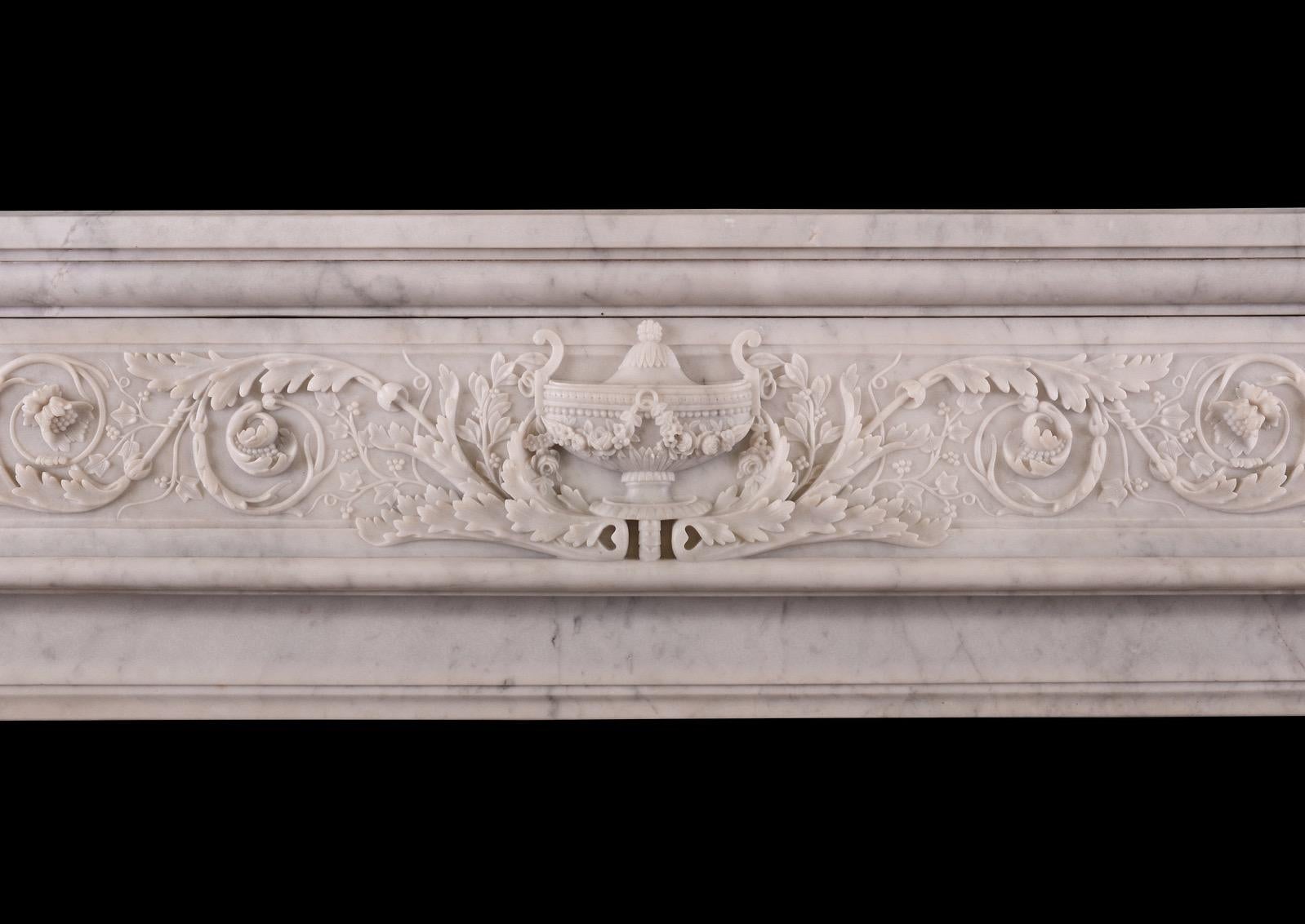 Cheminée française du XIXe siècle de belle qualité, de style Louis XVI. Les montants à volutes sont ornés d'une moulure en corde et de feuilles d'acanthe sculptées. La frise finement sculptée de rinceaux, de feuillages et d'une urne classique au