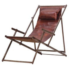 A.I.C., chaise longue pliante en fer et cuir, C. 1970.