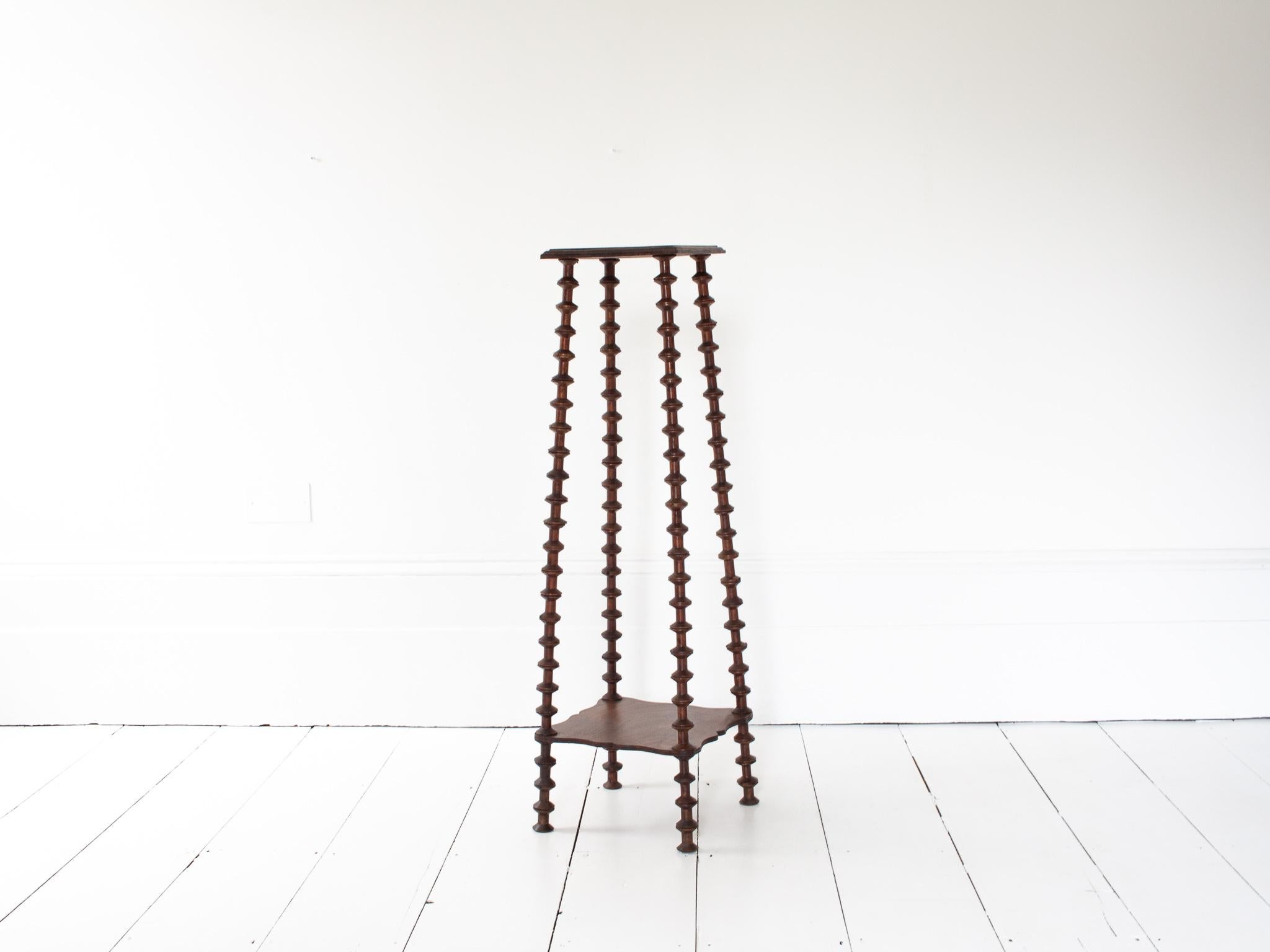 A French folk art plinth/etagere – formed from used sewing spools which are stacked and supported internally with rods with both lower and higher tiered shelves. 

The plinth form most probably dates from the 19th Century.

Befitting of interiors
