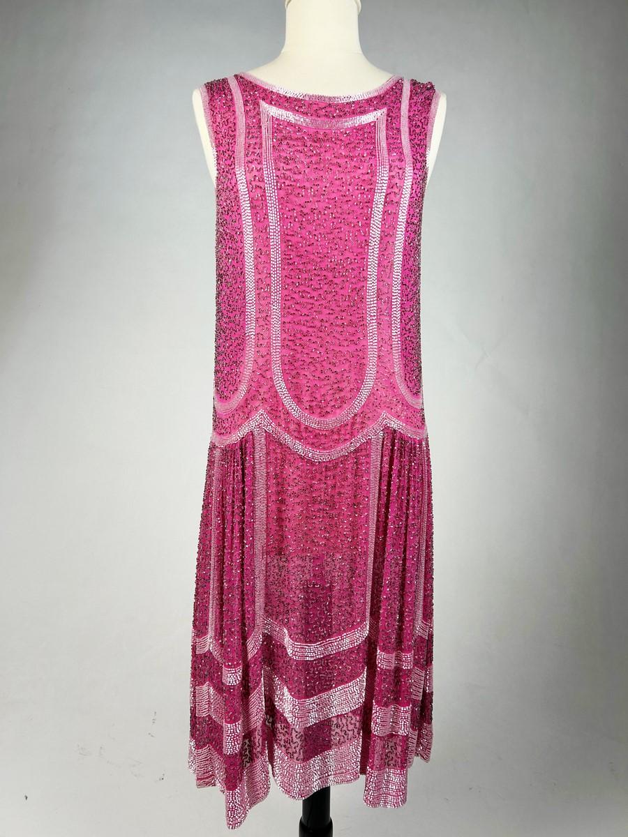 Circa 1925
France

A French Falpper dress in pink fuchsia cotton voile embroidered with white tubular glass beads dating from the Twenties. Embroidered and vermiculated back giving a sandblasted effect.  Fluid dress with straight cut and low waist