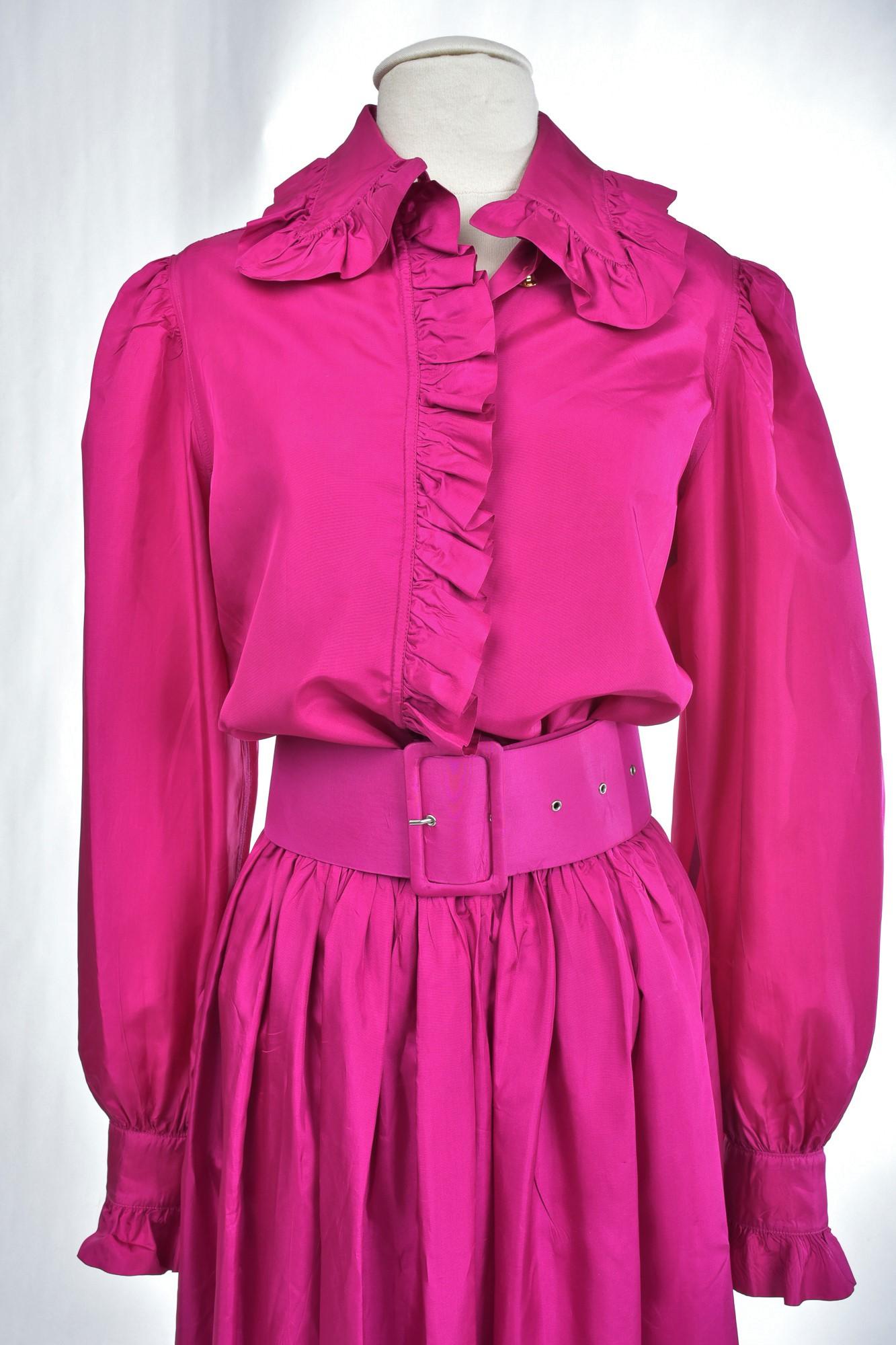 Circa 1990

France

Dramatic skirt, blouse and belt in acetate taffeta Fuschia by the Parisian designer Popy Moreni and dating from the 1990s.  Blouse blouse long sleeves puffed collar highlighted by falbalas gathered with recall on the front and