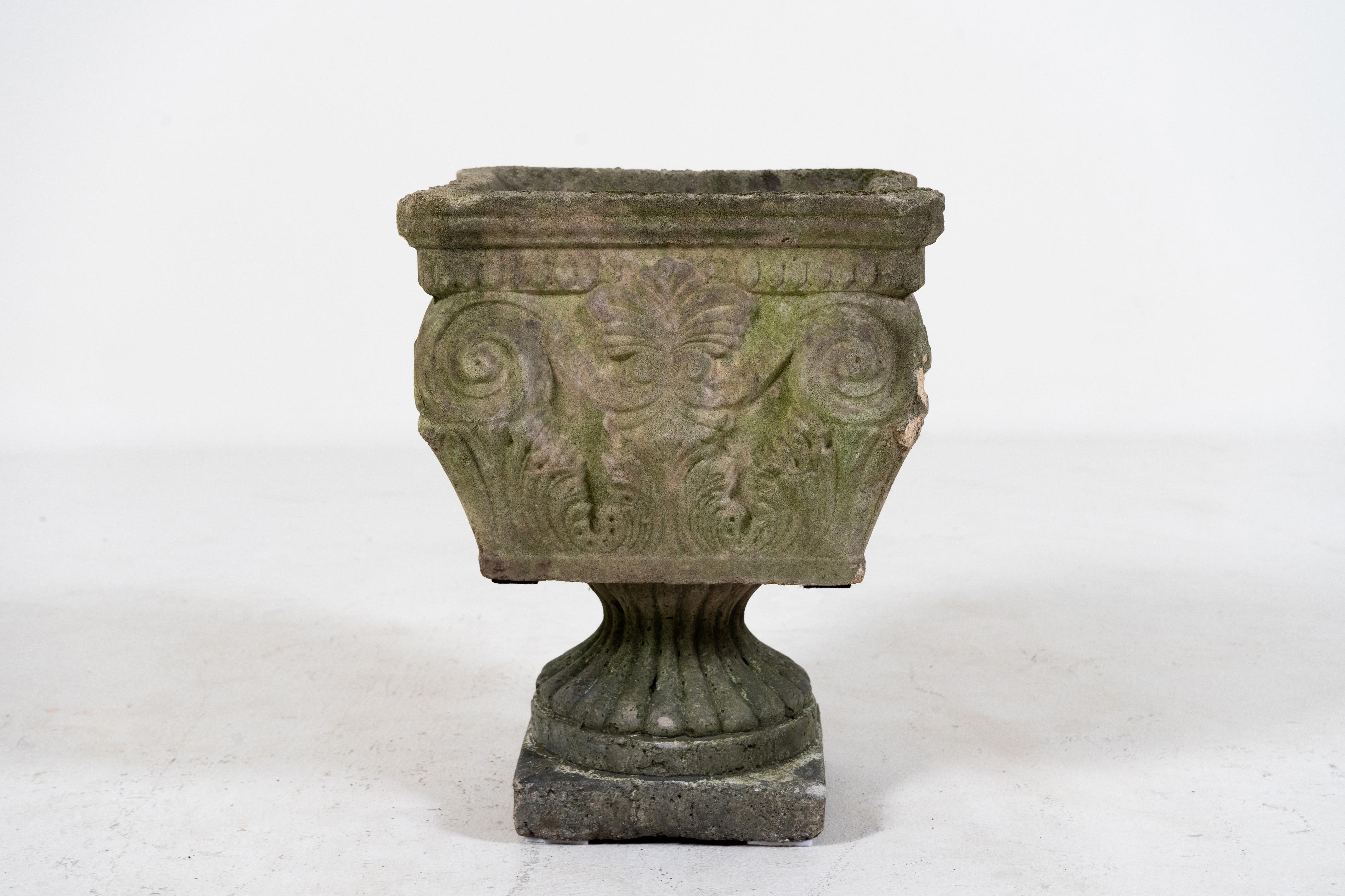 This vintage French jardinière has a playfully idiosyncratic appearance. It is squarish in form, loosely based on a Greek column capital. Ionic scrolling and acanthus leaf motifs are clearly visible. The basin rises above a lobed base and square