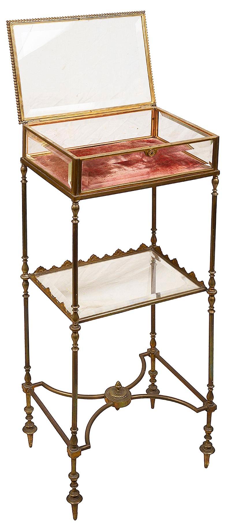 A good quality French turned brass and bevelled glass bijouterie table with original velvet interior a single glass shelf with shaped brass gallery and a shaped stretcher beneath, circa 1890
Batch 70  G9777/22  YNKZ