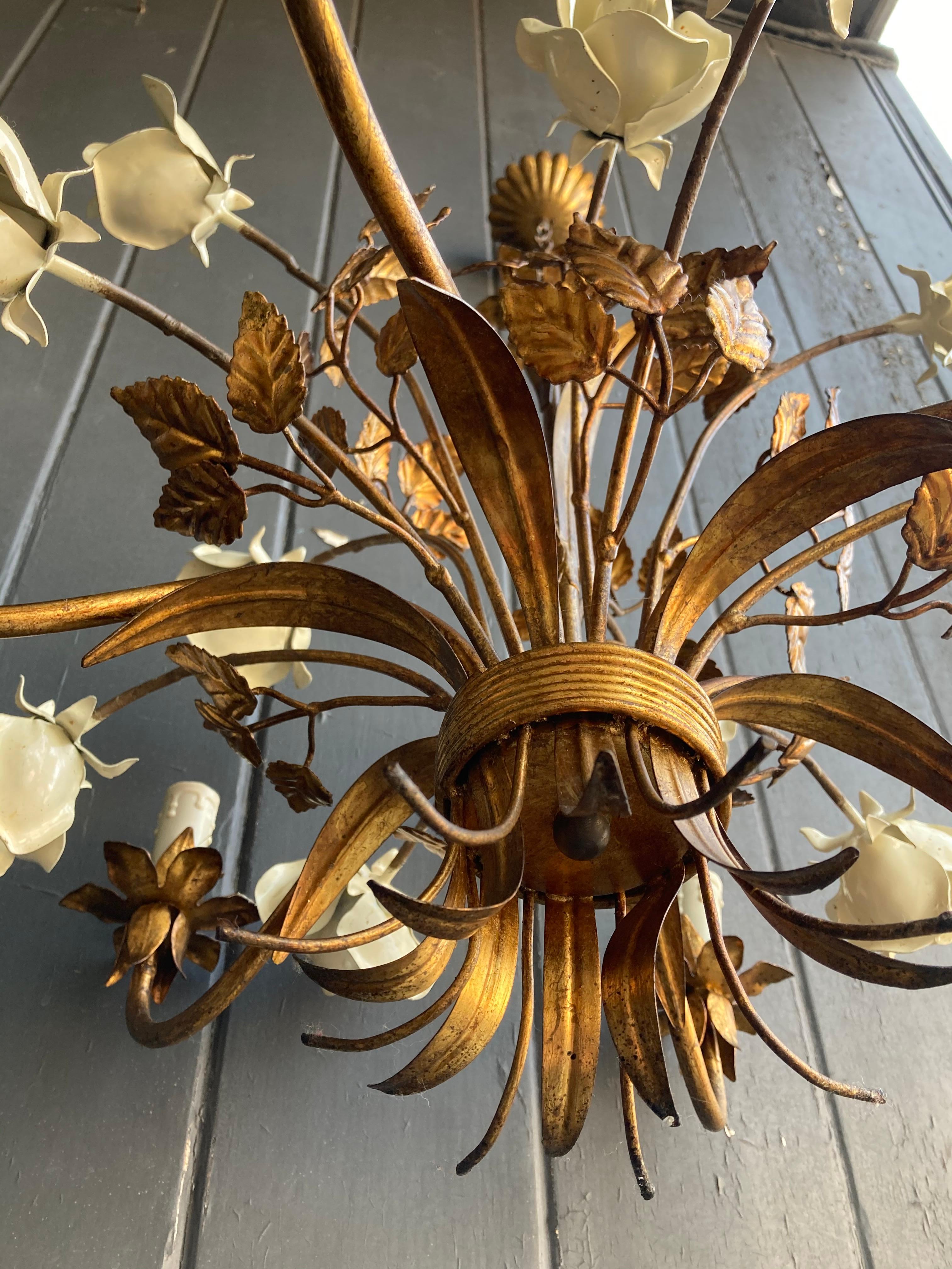 A French painted gilt metal and enamel painted tôle chandelier with large cream roses and luxuriant-looking foliage. It is a soft gold color, and has six arms giving lovely light.



The actual chandelier is 60cms from top to bottom, the chain