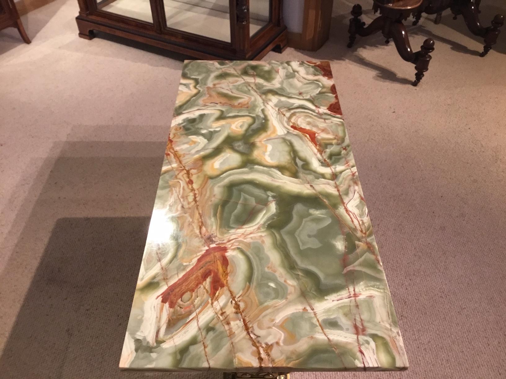 A French gilt brass and onyx antique coffee table. The rectangular green and red veined onyx top raised on elaborate Rococo style columns with cast paw feet. French circa 1920

Dimensions: 42