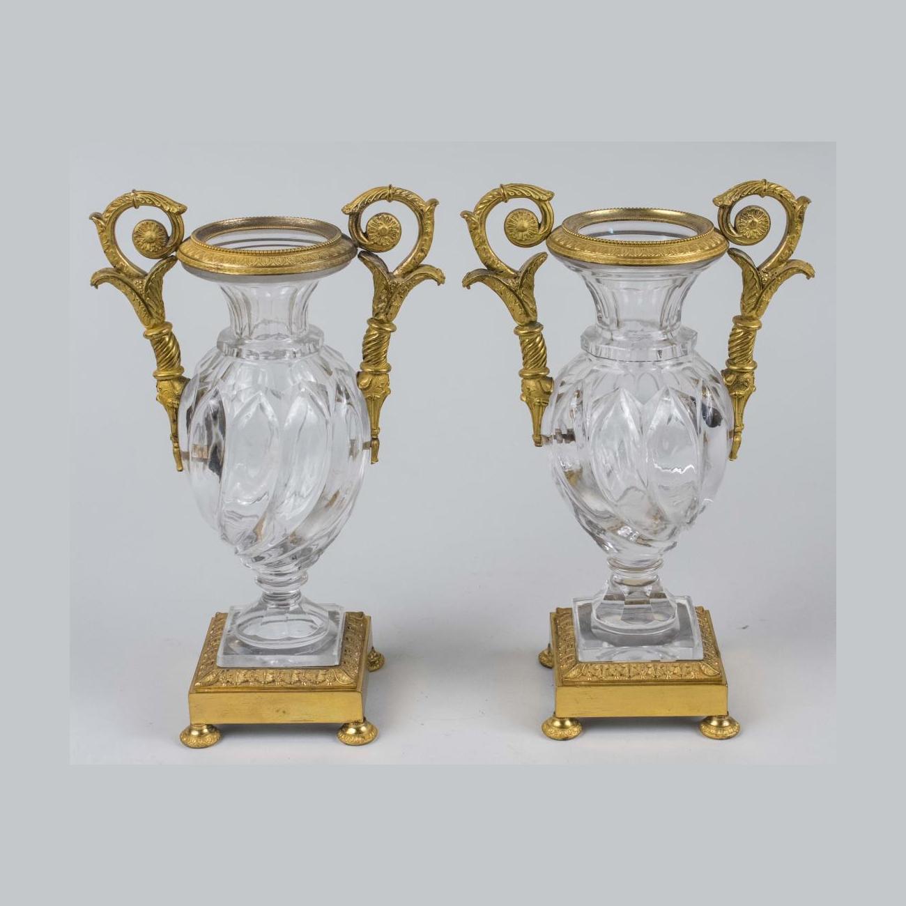 Un elegante orologio francese in bronzo dorato e vetro.
Orologio a forma di urna in bronzo dorato montato su cristallo con minuteria smaltata con numeri romani, decorato con una coppia di figure femminili a termine, insieme a una coppia di urne