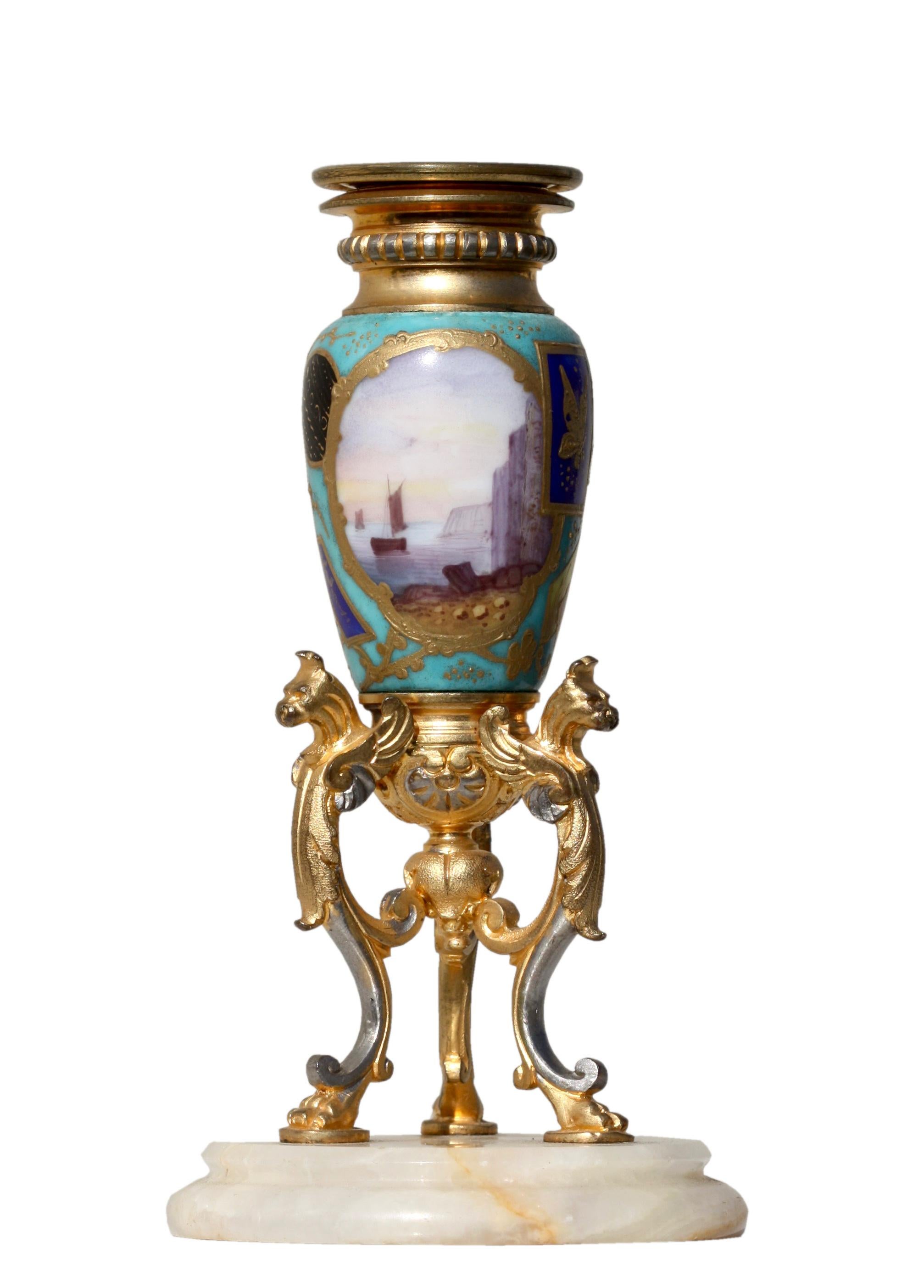 A French gilt bronze and Sevrès style porcelain-mounted candle stick 
19th century, the bronzes in Louis XV / XVI Transitional style, on a onyx stepped round base
Measures: Height 6 inches, width 3 1/8 inches.