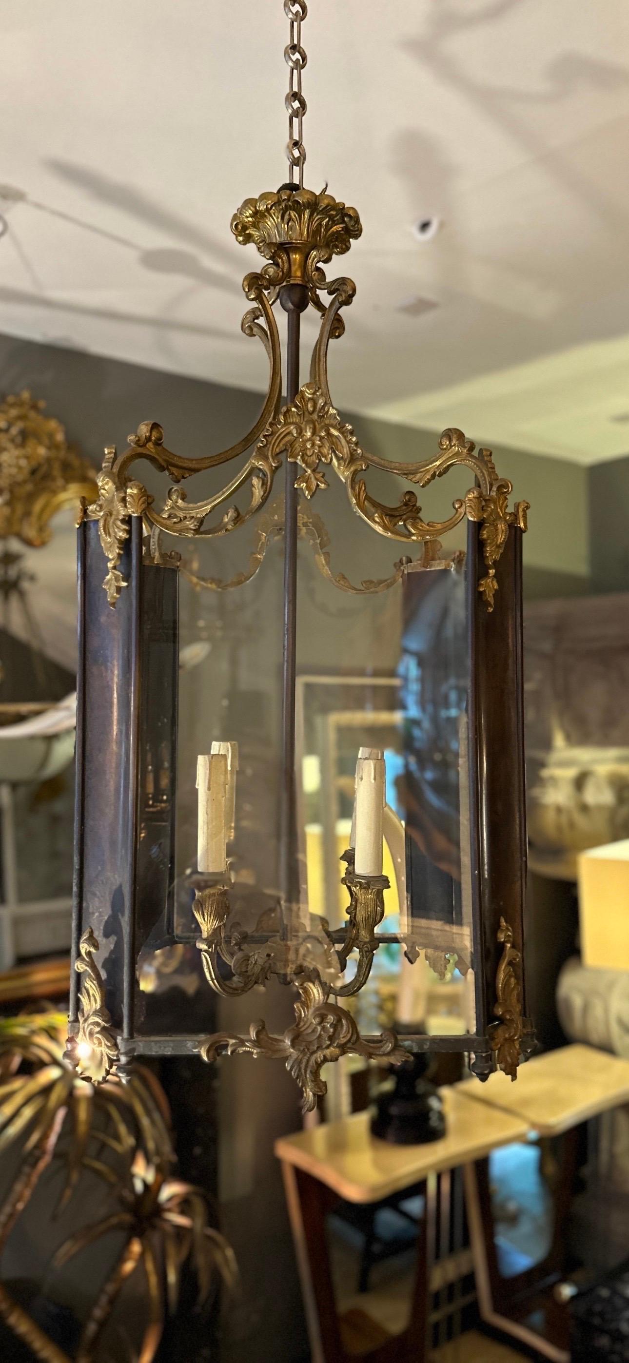 A large square lantern from the Napoleon III period, in Gilt bronze and Patinated bronze. Decorated profusely with scrolls, shells, acanthus and foliate. The canopy with acanthus top, C scrolled arms supporting patinated panels decorated with