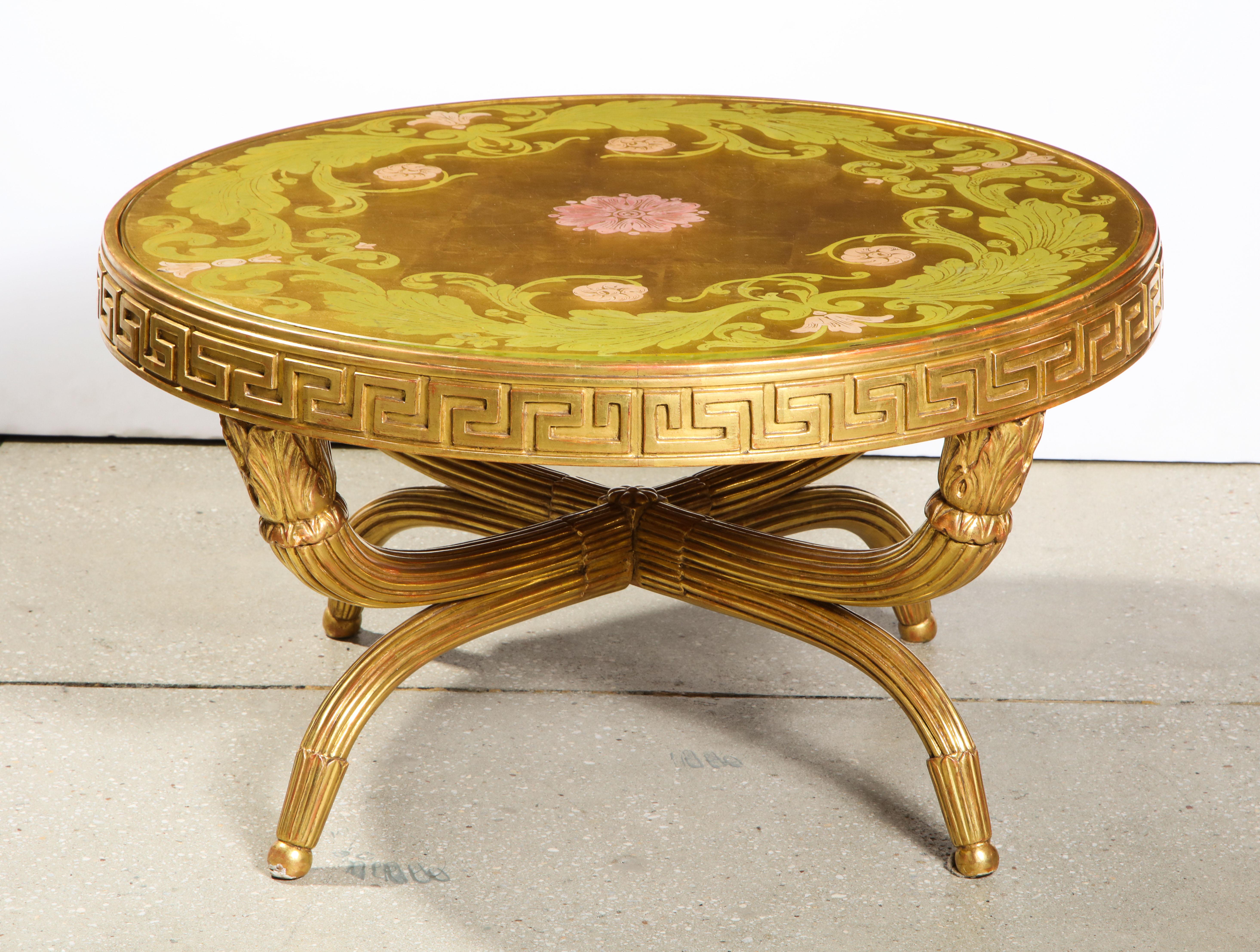 The Églomisé and gilded glass top inset into a giltwood table having a 