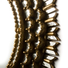 A French giltwood oval mirror in the manner of Line Vautrin, C 1970.