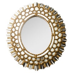 A French giltwood oval mirror in the manner of Line Vautrin, C 1970.