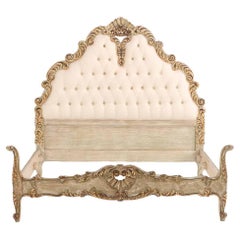 A French Hollywood Regency style painted and gilt carved full size bed, C. 1940.