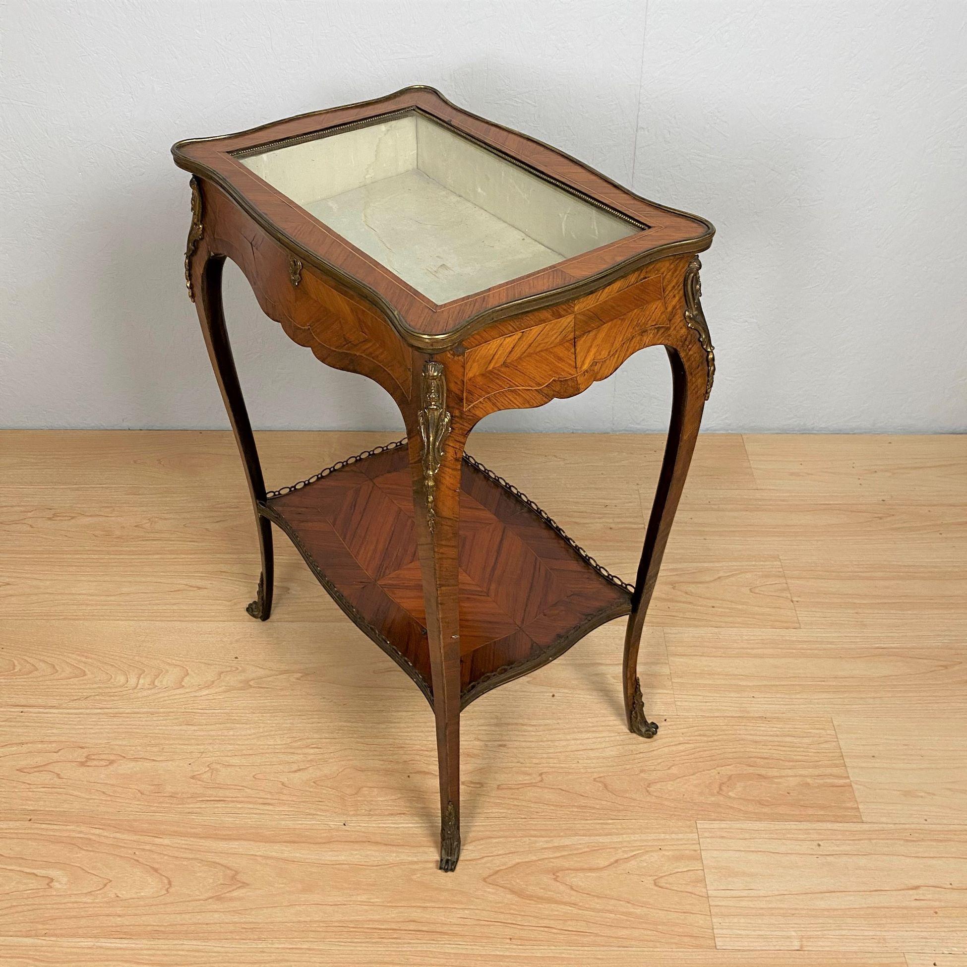 A French kingwood and brass metal mounted bijouterie table of Louis XV design.
The serpentine shaped and glazed hinged top enclosing a cream silk lined interior that sits above a shaped apron.
The whole raised on brass-mounted serpentine legs that