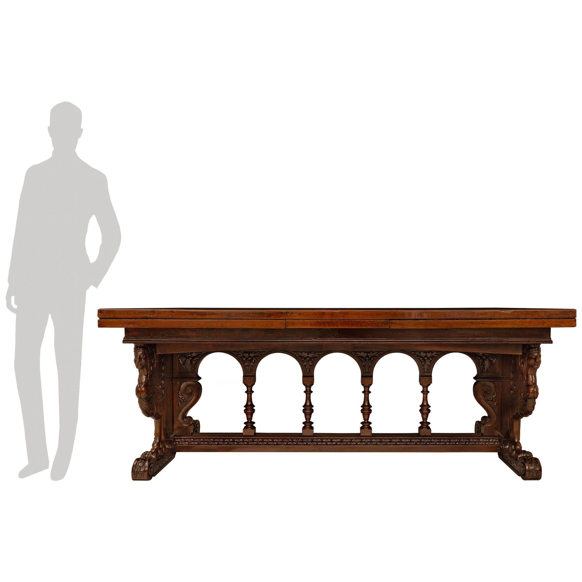 Très belle table de salle à manger en noyer de la Renaissance française de la fin du XVIIe siècle, finement détaillée. Cette belle table avec ses extensions d'origine présente un cadre central richement sculpté contenant quatre colonnes tachetées