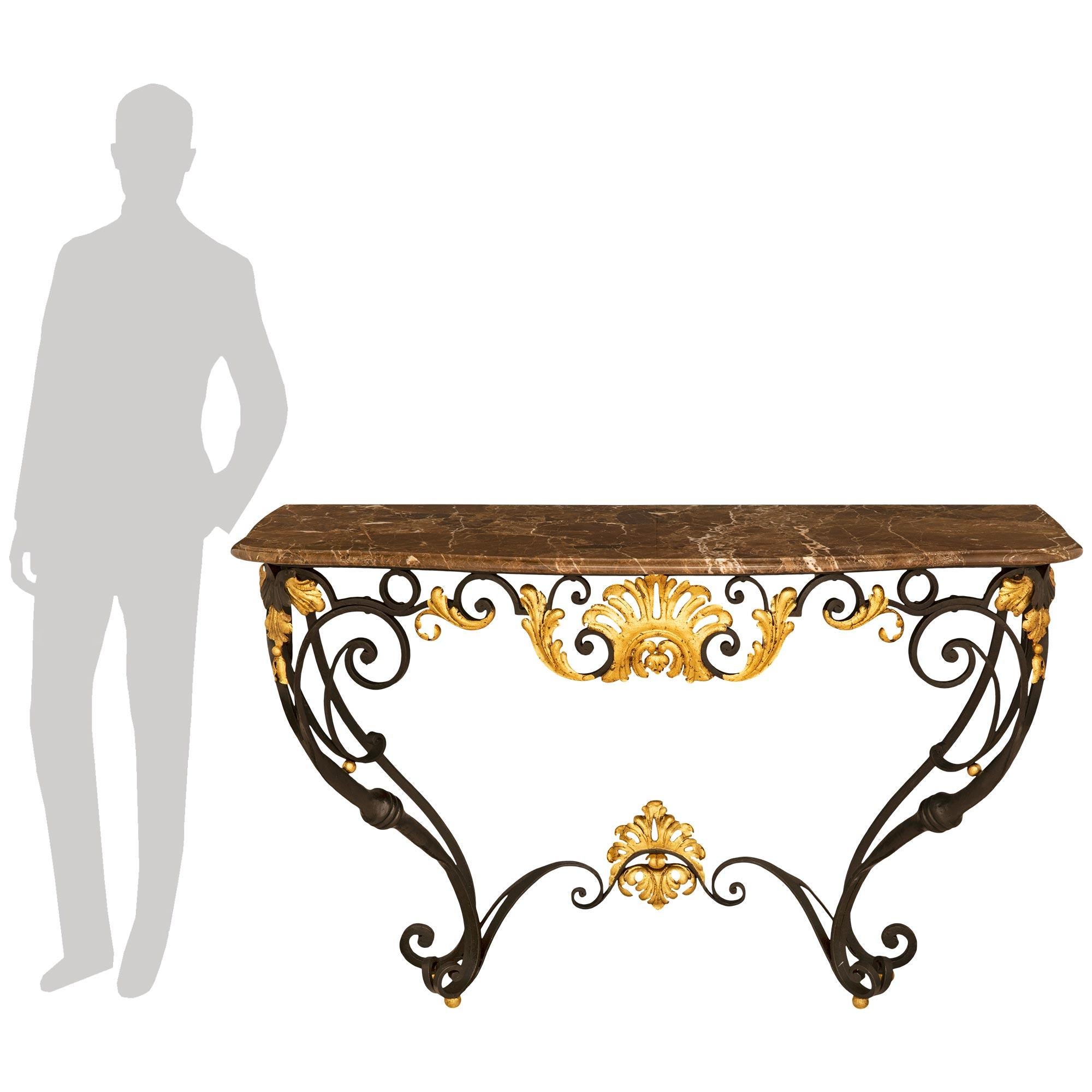 



Belle console française de la fin du XIXe siècle de style Louis XV en fer forgé, métal doré et marbre. La console est surélevée par des pieds à volutes au-dessus des pieds boules dorés et est reliée par un châssis à volutes présentant une